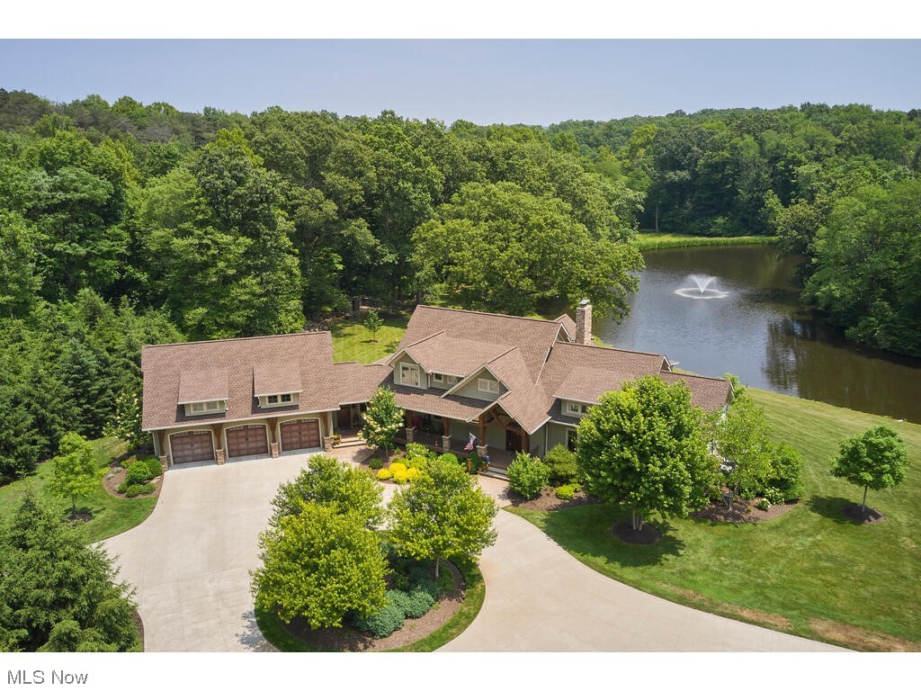 Nestled amid the breathtaking beauty of CVNP, this remarkable home & property offers a truly enchanting retreat. Located in the Village of Peninsula, this property provides easy access to restaurants, shops, Szalay's, walking/biking trails, & Boston Mills/Brandywine Ski Resort. Custom-built in 2013 by Steve Moore, this rustic-style home sits on a sprawling 22+ acre lot, featuring a 2-acre lake w/depth of 12 feet. With 4 BDS and 3.5 BA, this residence offers a thoughtfully designed layout. The main level showcases an owner's suite w/luxurious full bath w/heated floors. The 2-story Great room has an impressive stone wdb FP. The chef's kitchen connects to the Great rm and dining area. FF private office, and a mud room off the 3-car heated garage. 2nd floor features 2 BDS, a full BA, & a loft area. The finished w/o LL is has BD 4, w/full bath, a rec room with FP (& plumbed for a kitchen/full bar), & a workout room. French doors in the kitchen lead to covered outdoor living space. A multi-tiered deck leads to an expansive patio & firepit area, overlooking the 2-acre lake. Take a stroll along the walking trails along the property or enjoy a friendly game of half-court outdoor basketball. A garden shed offers storage. The stone walls surrounding the outdoor patio came from Athens County (Jackson County Jail). Whole house generator. Don't miss the opportunity to experience the beauty and exceptional features of this extraordinary property. Call today to schedule your private showing!