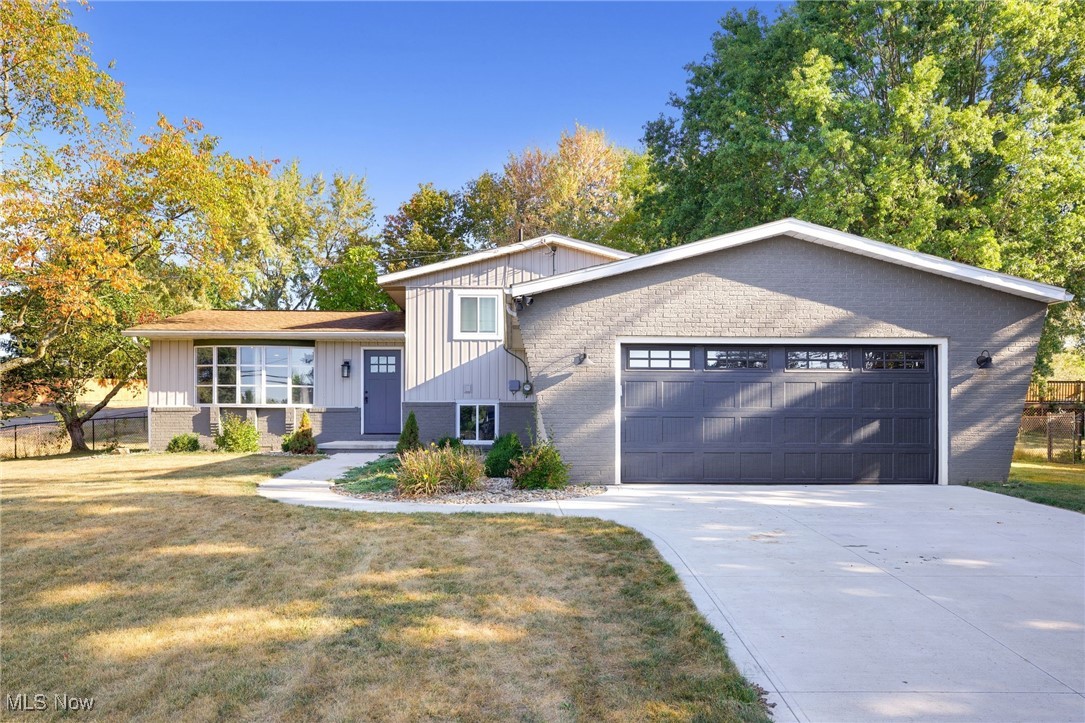 Welcome to 3135 Nimishillen Church St, a beautiful split-level home set on approximately half an acre in the serene countryside of Hartville and in the highly-rated Lake Local Schools! The exterior shines with new board and batten vertical siding, new garage door, fresh paint, and a pristine concrete driveway with matching sidewalk. Step inside to discover an inviting open-concept design that effortlessly merges style and functionality. The first floor captivates with its large front window, inviting in the beauty of the outdoors and creating a warm atmosphere. New bannisters and sleek metal spindles add a contemporary touch, ensuring seamless flow into the living room. The brand new eat-in kitchen boasts shaker-style cabinetry, stylish hardware, newer appliances, new stone countertops, subway tile backsplash, dedicated dry bar, and generous center island providing extra seating and workspace for meal preparation. Check out even more updates, including new interior doors, luxury vinyl plank flooring, and plush carpets throughout both levels. A custom mudroom adjacent to the garage offers ample storage, complete with hooks and a cozy bench seat. Enjoy the convenience of a laundry room equipped with a utility sink and a brand new water softener. The updated second level includes a freshly remodeled bathroom with double vanity and new fiberglass tub, designed for relaxation and style. Venture outside through the sliding glass door to your private fenced-in backyard. Here, a concrete patio awaits, perfect for entertaining or enjoying quiet evenings, complemented by a handy storage shed. With a brand new air conditioner, a newer roof, new septic system, and new garage door, this home is not only aesthetically pleasing but also equipped for modern living. Don't miss out on this remarkable opportunity to own a beautifully updated home in a tranquil country setting. Schedule your private showing today!