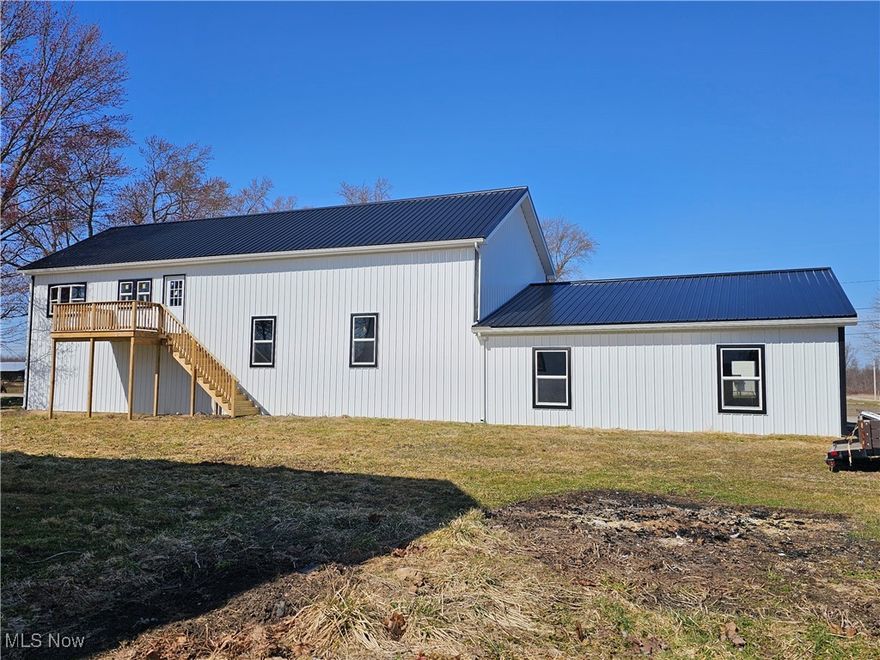 So much opportunity in this large building. Fully updated exterior with new aluminum siding and roof, gutters, windows, man doors and deck. The inside is ready to be used for storage or finished for a second story apartment and business. 12-foot overhead door and 4-inch newly poured interior cement pad. 200-amp service for electric.