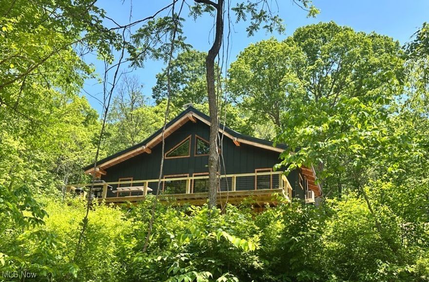 Escape to your own secluded 45.947-acre paradise, designed for the true outdoor enthusiast. Nestled deep in nature, this recreational retreat features a brand-new off-grid, solar-powered A-frame cabin that comfortably sleeps 10-12. Crafted with 8x8 timber framing from red oaks harvested on-site, and finished with hickory floors and pin oak trim, the cabin blends luxury with sustainability along with an abundance of finer touches. Energy-efficient mini-split HVAC system installed to provide year-round heating and cooling comfort, ideal for off-grid or remote living. Mounted securely on the exterior, this unit offers quiet, reliable climate control with low energy consumption, not to mention a beautiful wood burner for those that want a crackling fire. Powered by 16 solar panels (450W each), 2 EG4 batteries, and a Luxpower 12kW inverter, this off-grid system ensures comfort in the wild. Wildlife abounds—deer, turkey, bobcat, squirrel, wood duck, grouse, barred owl, and more. Relax on the front deck overlooking a serene pond with a bedrock bottom. Retaining wall was made from on-site stone. A second wall features hand-laid foundation stones from a historic Mansfield schoolhouse. Approx. 1 mile of trails and a small food plot offer year-round adventure. Whether you hunt, hike, atv ride or simply enjoy nature, this rare, private getaway is where peace meets precision. The driveway ascends with a tasteful incline, offering beautiful views and a grand entrance to the home that enhances the property’s secluded feel.