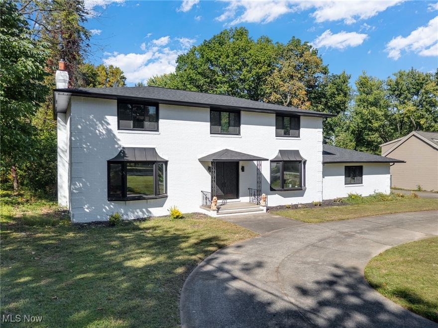 This stunning brick center-hall colonial combines timeless style with modern updates. Set on a private, tree-lined cul-de-sac lot with 120 feet of frontage and a circular driveway, this home offers four bedrooms, two full baths, and two half baths. Step through the double-door entry into the impressive two-story foyer and enjoy generously sized living, dining, and family rooms that make entertaining easy. The fully updated kitchen features granite countertops, an island, and a large pantry, with all appliances included. Freshly painted inside and out, the home also boasts a new roof and new A/C for peace of mind. Upstairs, you'll find three spacious bedrooms plus a large primary suite with dual walk-in closets and a private bath. The finished basement is designed for entertaining with a full bar, second kitchen area, and half bath, ideal for gatherings or extended-stay guests. Car enthusiasts will love the oversized attached garage with an 18-foot door, heat, hot and cold water, and utility sink, PLUS the additional detached garage/workshop with gas and electric service. Outside, enjoy a spacious backyard with a large deck, perfect for relaxing or hosting summer get-togethers.