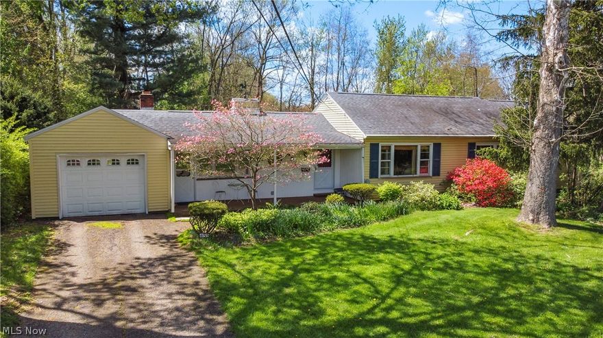 Set on a rare nearly one-acre parcel in Perry Schools, this character-filled ranch  offers a peaceful setting with mature trees, flowering dogwoods, azaleas, perennial gardens, expansive lawn space, and a tucked-away feel just minutes from Sippo Lake Park. A front driveway and long side drive lead to both an attached garage and detached garage, creating exceptional parking, storage, workshop, or hobby flexibility. One of the home’s standout features is the full walkout lower level, where a partially finished walkout room with private exterior entrance, driveway access, natural light, and a nearby three-quarter bath creates outstanding potential for a 3rd bedroom, private office, multigenerational living, studio, rental, or home business. Inside, timeless mid-century charm blends with functional living spaces through a tiled foyer, classic plaster archways, and hardwood floors flowing through the living and dining rooms. The bright front living room features 2 large picture windows, while the spacious family room is anchored by a dramatic floor-to-ceiling sandstone fireplace with raised hearth and clerestory windows. The skylit kitchen offers oak cabinetry, peninsula seating, generous workspace, brick-pattern backsplash, and included appliances, with a breakfast nook and views over the rear gardens and decorative lilly pond and leads to the oversized screened porch and brick paver patio provide ideal spaces for relaxing or entertaining while enjoying the privacy. The oversized primary bedroom includes skylights, abundant closet storage, and an adjoining sitting room with potential for an office, nursery, dressing room, or easy future ensuite bath conversion. A second spacious bedroom with 2 large closets and full bath complete the main level. Enjoy affordable utility rates including excellent Aqua Ohio water. Rarely does a property combine land, privacy, character, multiple garages, and suite or work-from-home flexibility so well. Schedule your private showing today.