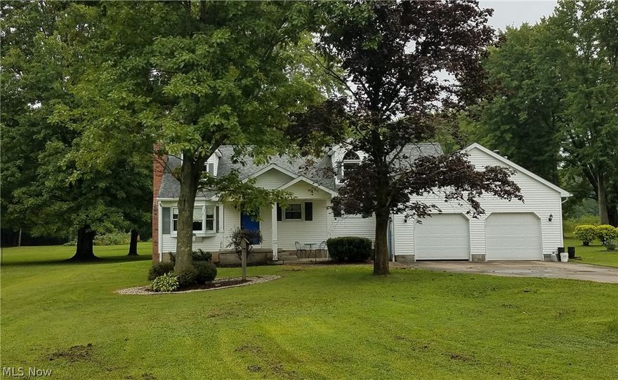 Peaceful setting with room to grow.  Located in Braceville Township just minutes from the Turnpike, this 1-1/2 story home on an acre lot awaits.  From the covered front porch,you enter the living room with plenty of natural light from the bay and double-hung windows.  From there, enter the eat-in kitchen with newer cabinets, counter and all appliances.  Follow through to a large family room with gas fireplace and sliders to the deck, or step into the garage or down the basement steps.  Back through the kitchen, you'll find the staircase to the huge second floor (which could serve as a third bedroom with some finishing touches)  and the hallway to two big bedrooms and full bath on the first floor.  A second full bath is located near the laundry area in the basement.  The oversized garage is attached to the house and a separate garage with covered patio provides space for your hobbies and a place to relax and enjoy the nature.  Well water supplies the house; with a tie-in to city water a