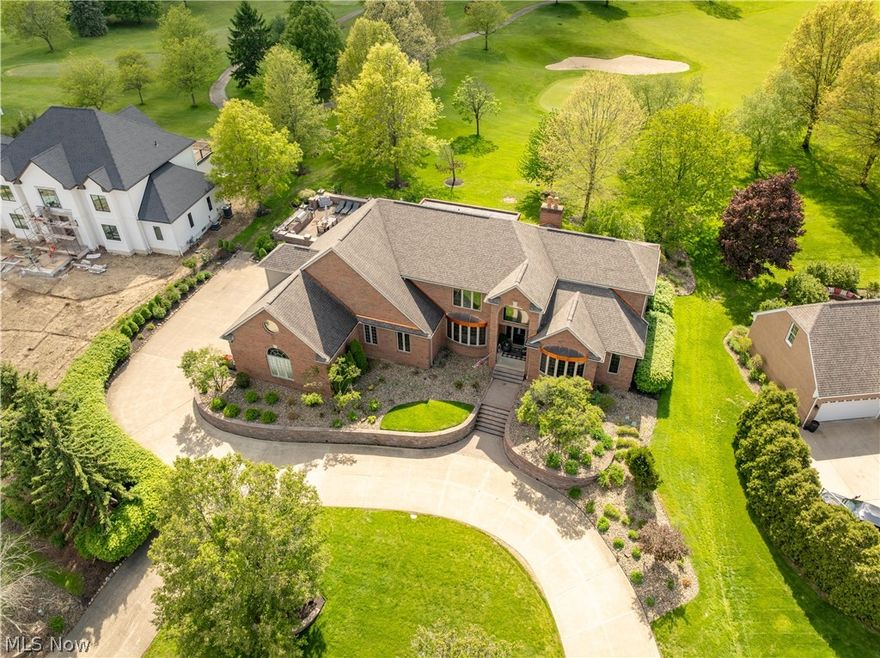 Welcome to this English-inspired brick estate, a must-see in person to fully appreciate its design, craftsmanship, and sweeping golf course views. Perfectly positioned along the 2nd fairway of Glenmoor Golf Course, it blends timeless elegance with refined modern luxury in one of the area’s most prestigious gated communities. Ideal for family living, entertaining, and a resort-style lifestyle, the home impresses from the moment you enter. Rich hardwood floors flow throughout the completely remodeled main level, creating warmth and continuity across the living spaces. A stunning first-floor office with vaulted, beamed ceilings and abundant natural light offers a serene, inspiring workspace. The dramatic two-story great room is anchored by a striking stone fireplace and framed by expansive windows capturing panoramic fairway vistas. Just beyond, the sunroom provides a light-filled retreat for relaxing or enjoying morning coffee. A cozy den off the kitchen adds a quiet space for reading or work. The remodeled kitchen is the heart of the home, featuring custom Amish cabinetry, Café appliances, an induction cooktop, and a custom beverage bar, making entertaining effortless. The first-floor owner’s suite is a private sanctuary with dual vanities, two walk-in closets, and a spa-inspired bath. Upstairs, a junior suite, two additional bedrooms, and a large bonus room provide versatile space for media, play, or lounging. The finished lower level adds lifestyle flexibility with a cozy fireplace, full bar, recreation area, fitness space, abundant storage, and rare direct garage access. Outdoors, a custom kitchen with a built-in commercial gas grill is perfect for gatherings and entertaining. With four bedrooms, four full baths, and two half baths, this exceptional home offers sophisticated living, breathtaking views, and a premier golf course lifestyle.