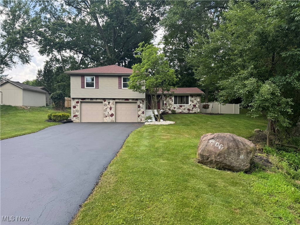 Welcome to this wonderfully maintained and uniquely charming split-level home, nestled on a quiet street in a serene, tree-lined neighborhood. From the moment you arrive, you’ll appreciate the inviting curb appeal, featuring a wide freshly sealed driveway, spacious dual garages, mature trees, and a well-kept lawn that provides a warm and welcoming first impression.
Step inside to discover a thoughtfully laid-out interior offering comfort, character, and functionality. The kitchen is both stylish and practical, classic white cabinetry, modern fixtures, and stainless steel appliances. A convenient breakfast bar connects the kitchen to the dining area, making it an ideal space for hosting and everyday living. The adjacent dining room features bamboo flooring and an elegant chandelier, creating a cozy yet refined atmosphere for entertaining.
Just off the dining room is a spacious living area with large windows that fill the room with natural light. The bamboo floors continue throughout much of the main level, tying the space together with warmth and continuity.
The lower level provides a generous finished basement space with custom wall paneling, brick accents, and fresh carpet — perfect for a home theater, game room, or creative studio. Also on this level, you’ll find a convenient half-bath and laundry area, offering added functionality to suit any lifestyle.
Upstairs, the home offers multiple large bedrooms with neutral tones, plush carpeting, and ample closet space. The primary suite includes its own private bathroom and dual closets for maximum comfort and storage.
A true standout is the additional family room that features a beautiful gas fireplace, perfect for relaxing evenings at home. Just off this space is a sunroom with large windows all around — an ideal spot for morning coffee or enjoying views of the lush, fully fenced backyard.
With plenty of indoor and outdoor living space, this home offers comfort, privacy, and charm in equal measure.