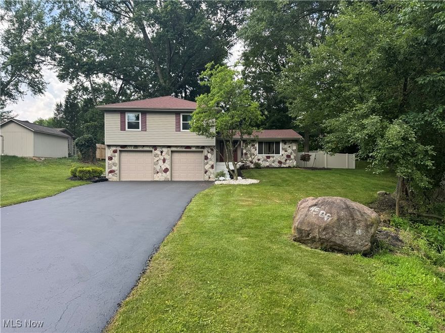 Welcome to this wonderfully maintained and uniquely charming split-level home, nestled on a quiet street in a serene, tree-lined neighborhood. From the moment you arrive, you’ll appreciate the inviting curb appeal, featuring a wide freshly sealed driveway, spacious dual garages, mature trees, and a well-kept lawn that provides a warm and welcoming first impression.

Step inside to discover a thoughtfully laid-out interior offering comfort, character, and functionality. The kitchen is both stylish and practical, classic white cabinetry, modern fixtures, and stainless steel appliances. A convenient breakfast bar connects the kitchen to the dining area, making it an ideal space for hosting and everyday living. The adjacent dining room features bamboo flooring and an elegant chandelier, creating a cozy yet refined atmosphere for entertaining.

Just off the dining room is a spacious living area with large windows that fill the room with natural light. The bamboo floors continue throughout much of the main level, tying the space together with warmth and continuity.

The lower level provides a generous finished basement space with custom wall paneling, brick accents, and fresh carpet — perfect for a home theater, game room, or creative studio. Also on this level, you’ll find a convenient half-bath and laundry area, offering added functionality to suit any lifestyle.

Upstairs, the home offers multiple large bedrooms with neutral tones, plush carpeting, and ample closet space. The primary suite includes its own private bathroom and dual closets for maximum comfort and storage.
A true standout is the additional family room that features a beautiful gas fireplace, perfect for relaxing evenings at home. Just off this space is a sunroom with large windows all around — an ideal spot for morning coffee or enjoying views of the lush, fully fenced backyard.
With plenty of indoor and outdoor living space, this home offers comfort, privacy, and charm in equal measure.