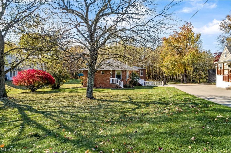 This beautiful, brick ranch-style home is roughly 1,500 square feet and sits on a 1.4 acre wooded lot. The large yard offers a serene park-like setting and is partially fenced in. A separate gazebo-style garage building features a three seasons sunroom with gas heaters. There is also a pole barn on the property– great for storing yard tools and patio furniture or it could be your workshop. The home has been immaculately cared for with many updates over the years. There are three bedrooms, a full bath, living room, and eat-in kitchen on the main level. The galley-style kitchen offers nice, hardwood cabinetry and a white tile backsplash. All the bedrooms are painted in neutral colors and feature refinished hardwood floors and ceiling fans. One of the bedrooms offers wall-to-wall built-ins and features sliding glass doors that lead to the deck. The walk-out basement has been partially finished and is in the process of being re-done again. The furnace and central A/C systems are both newer