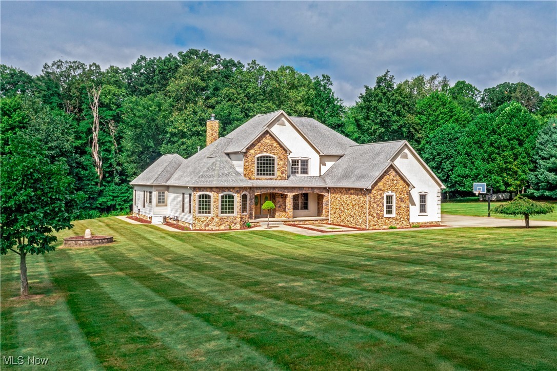 Set on 2 private acres, this magnificent custom-built colonial was designed to impress at every turn. From the moment you step inside, you’ll be struck by the home’s soaring scale, exquisite details, and masterful craftsmanship.
The dramatic two-story foyer sets the stage for grand-scale entertaining and intimate gatherings alike, with 20-foot ceilings and sweeping sightlines that pull you into the heart of the home. The dining room stuns with a tray ceiling and dazzling chandelier, and the soaring great room provides a perfect backdrop for memories to come.
The chef’s kitchen blends showpiece design with pro-level function. Custom cabinetry, granite counters, and a wall of windows with tailored blinds set the scene, while a professional-grade Viking cooktop with hood, a wall oven/microwave combo, beverage cooler, and dedicated ice maker make entertaining effortless.
The main-floor owner’s suite is a private retreat with vaulted ceiling, his-and-hers closets, spa bath, and patio access, blending indoor comfort with outdoor ease. Upstairs offers three spacious bedrooms, including one ensuite and a Jack & Jill layout. The finished lower level transforms into the ultimate entertainment hub: billiards, foosball, air hockey, basketball, a home gym setup, dual TV lounges, and a full bath with an oversized step-in shower.
Every practical detail has been considered: first-floor laundry with washer and dryer, 3-car heated garage with key lock storage, drains, hot/cold water, and three openers. Whole-home luxuries include a sound system, surveillance system, Generac generator, two Lennox furnaces, and Rinnai tankless water heater.
Outside, enjoy stamped concrete walkways, a stone-covered front porch, concrete patios with retractable awning, sprinkler system, and beautifully landscaped grounds that create a seamless blend of luxury and nature.
More than a home—this is a lifestyle statement. Schedule your private showing today.