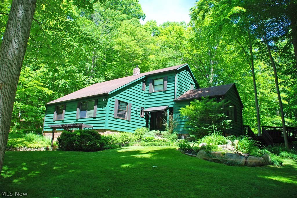 1.7 acres of pure serenity. From the moment you drive up the circular drive, you are surrounded by nature’s finest. From mature trees, to a home perched on a hillside, with a majestic ravine, creek with interesting shale bed, and mature, elegant landscaping, the peacefulness of this setting will instantly be felt. Ample parking and a 3-car garage with an addl workshop area. Expansive rear deck w/complete privacy. Lower level is a walk-out in the front w/stone patio. Raised bed perfect for growing herbs. The open floor plan w/vaulted ceilings, back wall floor-to-ceiling windows & slider overlooking the ever-changing landscape of all 4 seasons to enjoy nature year-round and this property will instantly feel like home. Hardwood floors galore on the main level along w/vaulted great room w/a beamed ceiling. Open dining room & large, spacious eat-in kitchen w/a café-style bar area which has direct access to the deck. Master bedroom w/2 closets & adjoining, updated master bath. Two other roo