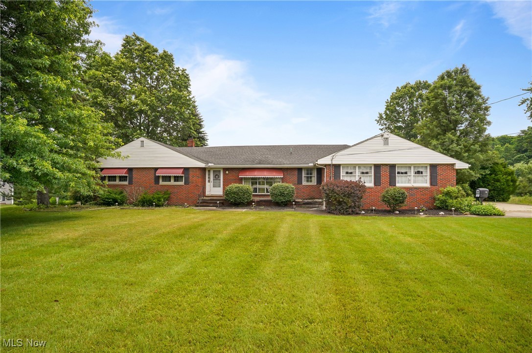 This sprawling brick Ranch situated on 1.3 acres is in a prime Aurora location. From the foyer entry with its slate tile floor you'll find a nice open floor plan that includes a bright and spacious formal living room and dining room which overlook the sunken family room with wood beamed ceilings, a fireplace and an extra gas heater. From the family room is a nice 17 x 16 room addition with closet that could be a 4th bedroom or sunroom. The warm and cozy eat in kitchen has lovely oak cabinets and plenty of natural light shining through the large picture window. There is also a first floor laundry room and 1/2 guest bathroom. Down the hall you find three bedrooms and two full bathrooms. The lower level has a king size rec room measuring 40 x 14. It has a beautiful large brick platform for the Ben Franklin wood burner. The basement also includes two more finished rooms and a full bathroom. Outside is a large concrete driveway and storage shed. New roof in approximately 2017 and new AC in 2020. This is a solid well built home which has been filled with love for many years. It is priced to sell with room in the price for updates.