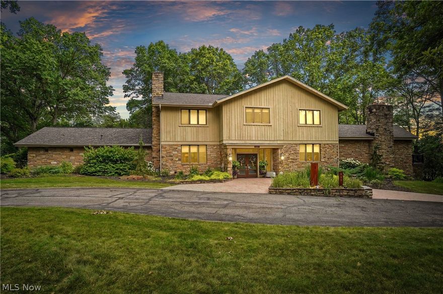 Welcome to 889 Eaton Ave., a Marchetta built stone and cedar contemporary home offering over 5,600 Sq. Ft. plus approximately 1,110 in the walk out lower level. Step inside the front door to the open foyer and your eyes will immediately see the wonderful open floor plan. To the left you'll enter the living room with fireplace that mergers into the eating area on your way into the white and bright, fully applianced kitchen with center island, breakfast bar and plenty of cabinets and storage. The kitchen connects to the spacious formal dining room and the wonderful Sun room overlooking the multi level patios, newer Trex decking and the large open back yard with plenty of trees. The main Great room is UhMazing! This room is about 41x25 with 14 Ft. high ceilings, great lighting, and a huge stone wall with fireplace PERFECT for entertaining and large family gatherings..  There is also a first floor office with walls of built-ins and 2 half baths. The 2nd floor includes 5 bedrooms with ensuite bathrooms and great closet space in each as well as the hallway that is filled with storage closets. Some recent improvements: New roof in 2021, new Furnace, Decking 2023, new carpet throughout in 2024, EV charger added, invisible fencing, Updated lighting: garage, laundry room, kitchen, office and outdoor lighting in the back, new microwave and cooktop and front landscaping in 2020. This location is ideal and close to downtown, the metro park area, Stan Hywet, Portage CC and great shopping and restaurants. Home is in the King school cluster