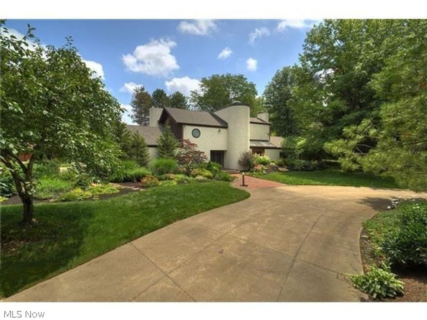 Country Estate in Bath! This Frank Lloyd Wright-inspired home features over 4,000 sq. ft. of living space on 9 wooded acres! First floor boasts an open floor plan with exposed beam ceiling in living room, kitchen & dining room. Updated kitchen with Jenn-Aire range, Sub Zero refrigerator, new counters and outlet system - never hunt for an outlet again! Rustic great room with Texas cork stone fireplace. First floor owner's suite features soaring two story ceiling with spiral staircase leading to library with tongue and groove cedar ceiling, master bath with his/her sinks, steam shower and sunken, heated spa tub; and walk-in closet with tons of built-ins! Second floor features 3 more bedrooms, all with access to balcony overlooking fenced backyard and 2 full baths. Third bedroom features a unique loft accessed by a ladder in closet, perfect hideaway for kids! Finished basement with bar. Three car side entry garage! Outbuilding with 2 car heated garage which could be used as studio or home