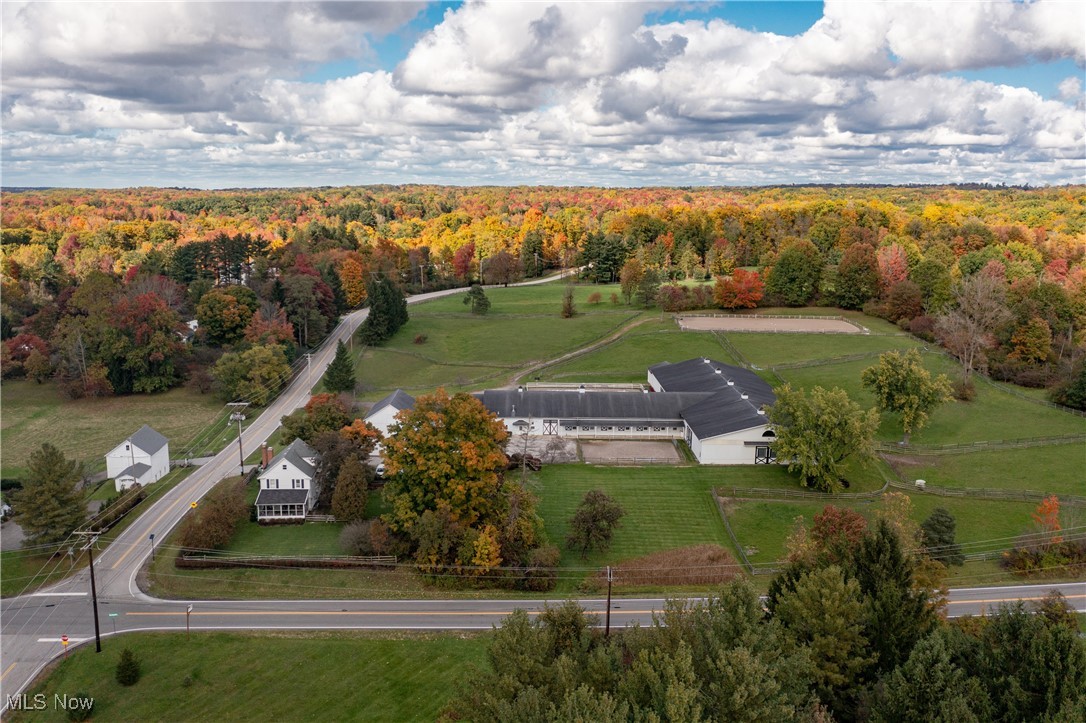 Situated on 10 sprawling acres on the edge of Hunting Valley and Russell Township, this incredible equestrian property is fully equipped with everything needed for a professional boarding facility. Highlights include an indoor riding arena, a 24-stall horse barn, 7 pastures, 2 turnout areas, and an outdoor riding arena. The indoor arena is 81x203 and Morton built with a watering system and heated viewing room / flex space. The barn includes 2 wash stalls, 2 tack rooms, multiple grooming stalls, a feed room, and a hay loft . Main Barn includes radiant heated floors and commercial washer & dryer. A heated lounge includes a kitchen, laundry area, and bath. The property includes a charming century farm house that is currently separated into two units: a 3 bedroom home and a one bedroom apartment with a private entrance. Apartment includes a full bath and laundry in basement and New AC unit in 2024. Located on 10 acres on the edge of Cuyahoga County and Geauga County, the property provides easy access to area amenities including parks, dining, retail and highways. Property offers Agriculture use Qualified C.A.U.V Tax Credit.