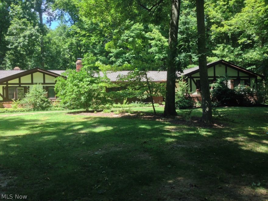Spacious 4 bedroom, 2.5 bath home with 2 large living areas, an eat in kitchen and a great screened sun porch with beams & a skylight overlooking a wooded yard.  This Tudor style ranch sits on 1.18 acres with a private setting in a lake community.  Although this house needs work and some TLC, it also has had some nice updates.  New roof 2013; new carpet installed in Aug. 2014; and laminate in the kitchen and dining rooms also .  So if you want to get into a fantastic neighborhood and are willing to do some work this is the house for you!  Seller moved out of state and could not finish the job. Gravel drive and brick walkways among a wooded yard with a jungle gym that stays, 2015 washer, dryer & all other appliances remain. Home warranty also comes with this house, as well as a newer well pump and in a public sewer neighborhood. The home is larger than tax records indicate. The original garage is now a family room!