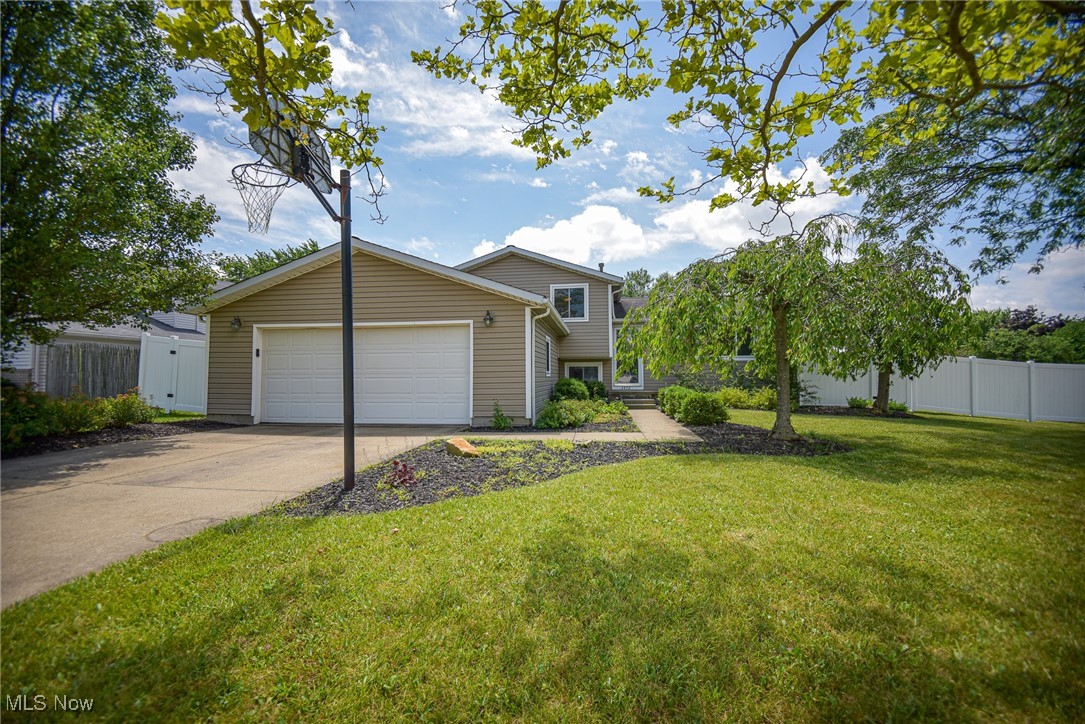 Welcome to this spacious 4-bedroom, 1.5-bath split-level home offering approximately 2,000 square feet of living space across four levels. Situated on a desirable corner lot, the home boasts a generous front yard and a fully fenced-in backyard with a vinyl privacy fence and two gated entries—perfect for outdoor enjoyment and peace of mind. Step inside the living room featuring a large picture window that seamlessly flows into the kitchen and dining area. The kitchen offers a convenient breakfast bar and opens to the dining room, where sliding glass doors lead to the backyard patio—ideal for entertaining or evenings by the firepit. Upstairs, you'll find three comfortable bedrooms and a full bath. The lower level features a cozy family room with a wood-burning fireplace and access to the attached 2-car garage. A fourth bedroom or home office, along with a half bath, completes this level, offering flexibility to meet your lifestyle needs. The finished basement adds even more space, featuring a rec room with new carpet and a dedicated laundry/utility room. Enjoy relaxing in the private backyard with a concrete patio, fire pit area, and handy storage shed. Brand-new AC unit (2025). With its spacious layout, multiple living areas, and inviting outdoor space, this home is a must-see!