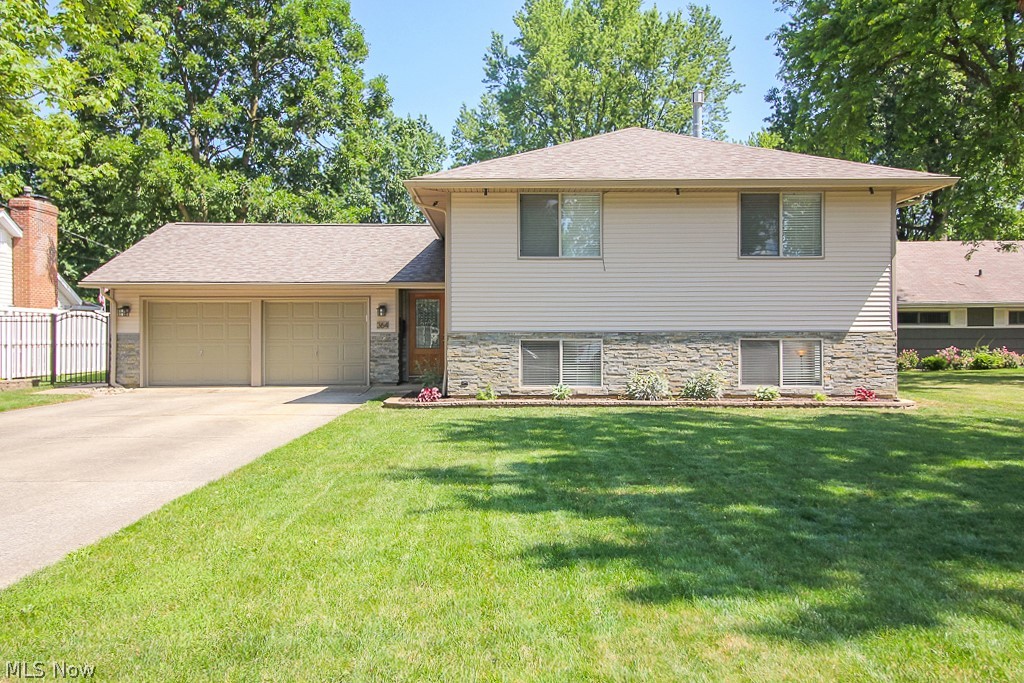 This lovely bi-level home will have you falling in love at first sight! From the curb you'll find a stylish home awaiting you, the layered stone front paired with premium vinyl siding is just a taste of what's to come! Inside you'll find an incredibly spacious home with large vinyl windows that fill the rooms with beautiful natural light. The main floor has hardwood floors throughout and features a bright living room, dining room and updated kitchen with recently installed cabinets, granite countertops and all stainless steel appliances! Plus there are 2 bedrooms as well as an entry way with a tile floors that continues into the full bath and the convenient laundry room with washer, dryer and built-in storage! In the spacious lower level you'll find the remaining 3 bedrooms, as well a beautiful full bath with tile surround and cozy family room with stone wall fireplace. The partially fenced-in yard is large and inviting - perfect for getting the most out of the warm weather - and has a