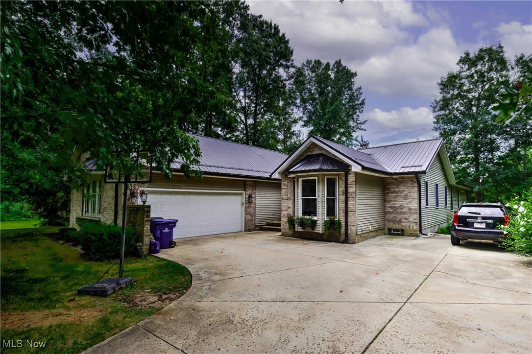 This stunning ranch sits on a private, park-like setting with an additional lot for extra space and privacy. The open floor plan features vaulted ceilings, skylights, and floor-to-ceiling windows that fill the living and dining areas with natural light. The living room centers around a cozy fireplace and flows seamlessly into the kitchen and dining spaces which are perfect for entertaining.
The spacious master suite offers patio access, a spa-like bath with a sunken garden tub, separate shower, double vanity, and a large walk-in closet.
The fully finished basement expands your living space with a full bathroom, bedroom, and a beautiful bar area, making it ideal for guests or game day gatherings. Outside, enjoy the large concrete patio surrounded by lush landscaping.
Additional features include first-floor laundry, fresh paint, a heated two-car garage, and a detached outbuilding for extra storage.