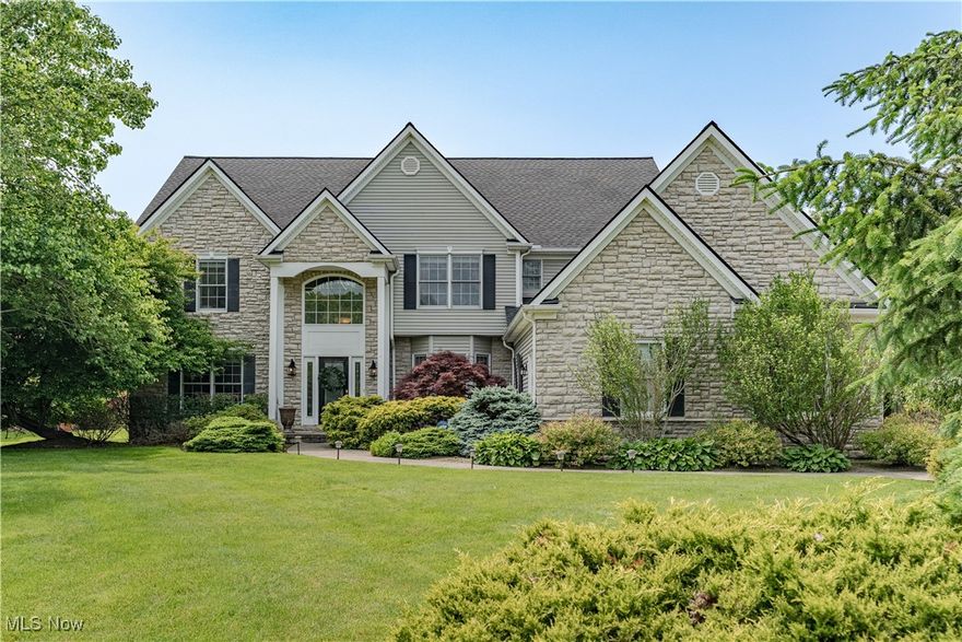 A refined and spacious traditional home nestled in one of Solon’s most prestigious communities, this residence masterfully blends timeless design with modern comforts in an exceptional setting. A leaded glass front door welcomes you into a dramatic two-story foyer, where newer hardwood floors flow gracefully into the formal dining room, accented by a tray ceiling and bay window—setting the stage for elegant entertaining. The dining room opens to a breathtaking two-story family room, flooded with natural light from soaring windows and centered around a stately fireplace that creates a warm, inviting atmosphere. The chef’s kitchen is equally impressive, featuring granite countertops, high-end cabinetry, a custom tile backsplash, and a spacious eat-in area with direct access to the private back deck—perfect for both daily living and entertaining. A formal living room adds versatility, while a beautifully appointed home office—accessed through French doors—offers built-in cabinetry, a bay window, and a dedicated workstation. Upstairs, the vaulted primary suite is a true sanctuary, complete with a cozy fireplace, expansive walk-in closet, and a spa-like bath with dual vanities, a jetted soaking tub, and a separate shower. Three additional bedrooms, including one with an ensuite and two sharing a third full bath, provide ample space for family or guests. The fully finished lower level expands the living space with a generous recreation room ideal for relaxing or hosting, along with a large utility room currently designed as a home gym. Outside, mature foliage frames the backyard for ultimate privacy, while the deck invites al fresco dining and serene outdoor enjoyment. Located just steps from the neighborhood park with a gazebo, playground, and scenic walking paths, this home offers elevated living in a community celebrated for its beauty, privacy, and convenience—an exceptional opportunity in the heart of Solon.