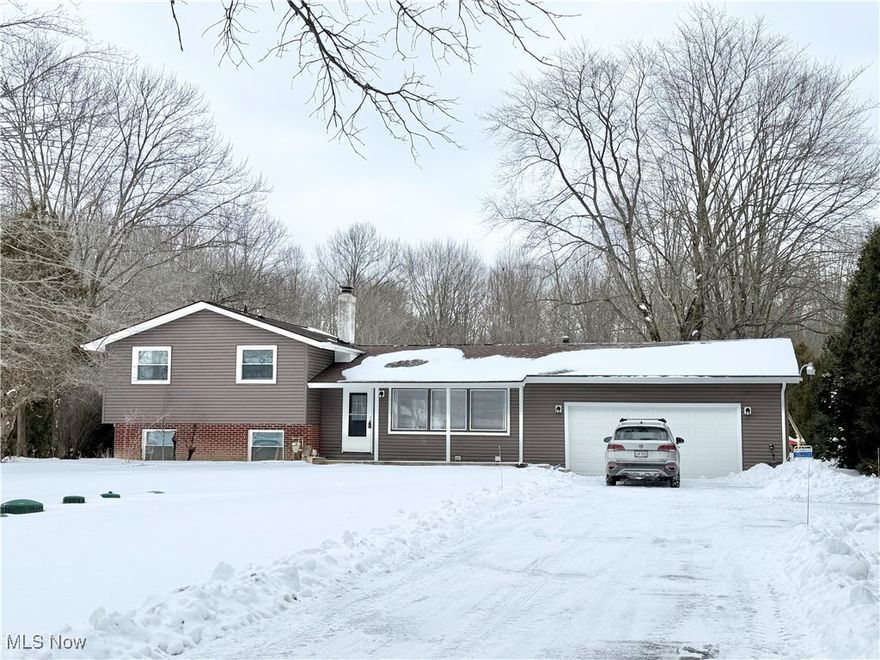 The property features a covered front walkway that leads into a foyer, which in turn opens into a formal living room and dining room characterized by vaulted ceilings and a skylight positioned above the dining room table. The living room is adorned with carpeted flooring, while recessed lighting highlights the clean, white trim throughout the space. The formal dining room affords views of the backyard and provides an opening that connects to both the lower family room and the kitchen. The kitchen has undergone a complete renovation and now boasts white soft-close cabinets, stainless steel appliances, a tiled backsplash, a spacious breakfast bar, and marble countertops that radiate under the central skylight. On the upper level, a generously sized full bathroom is accessible from the master bedroom, allowing for private entry, while an additional pair of bedrooms lines the corridor. The lower family room connects to a bonus room that can serve as an office or potentially a fourth bedroom, alongside a thoughtfully updated full bathroom that features a unique curved shower. The basement houses laundry facilities, including a washer and dryer, a laundry sink, a water softener, as well as sump pumps equipped with battery backup. The exterior features a newer above-ground swimming pool. Recent upgrades include: new vinyl siding, windows, a furnace, a hot water tank, a garage door, updated electrical systems, and a new septic system installed in 2020.