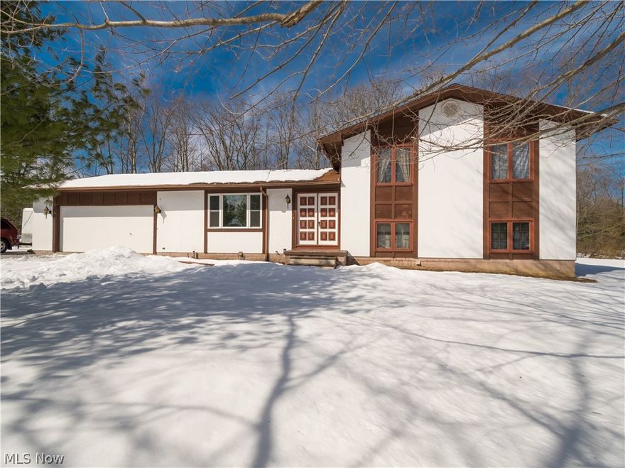 1 Year Home Warranty! Welcome! Well cared for tri-level one owner home has been updated to highlight the space and charm! Located on a 4-acre wooded lot within walking distance to Claridon Park. Exterior front is all new stucco w real redwood trim. Stained mahogany veneer paneling completes the rest of the house. 24 x 32 foot finished, 2 story Utility Building; insulated/heated w concrete flr, wired for an entertainment system. Plenty of room to park your toys, maneuver vehicles, large driveway w turnarounds. Septic system inspection approved 2017. Inside enjoy fresh paint, all new laminate, carpet flooring, new open concept breakfast bar in the kitchen. Cozy up to the custom stone wood burning fireplace & enjoy some privacy in the finished den w hardwood flooring. Plenty of storage, many large closets throughout.  Large Master bedrm w full bath & double sinks. Summer comfort w central air.  Attached 2 car garage provides cover from the elements. 24 X 32 ft. heated and insulated barn a