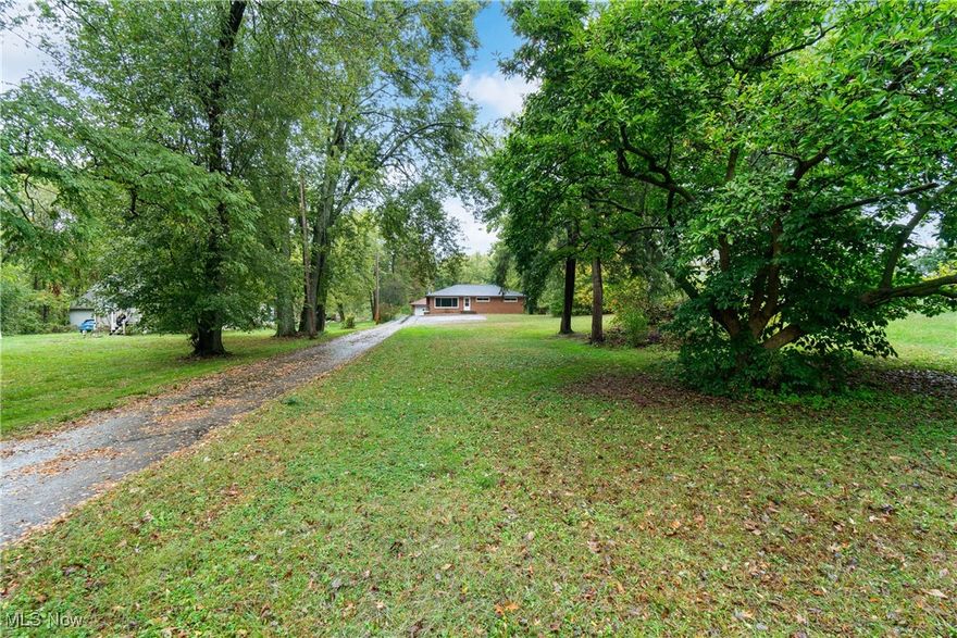 This beautifully redone brick ranch in the desirable Green Local School District offers turnkey living with room to grow. Set on a spacious 0.7-acre lot, this home blends timeless charm with thoughtful modern updates. Step inside to find refinished hardwood floors, modern paint colors, new ceiling fans and light fixtures, and high-end accents like warm wood-plank walls and built-in shelving. The inviting living room features a large picture window that fills the space with natural light and a new Buck Stove wood-burning fireplace with a stunning stone surround. The dining area flows seamlessly from the kitchen and opens to a composite deck (’23) overlooking the private, landscaped yard, complete with a small pond and mature trees. The home offers 3 bedrooms and 2 full baths, including a recently renovated main-floor bath and laundry room for added convenience. The partially finished basement includes a second full bath and laundry area, with Drylok basement sealing recently completed, and potential to expand the living space even further. Outside, you’ll find a detached 2-car garage with an attached workshop, new parking pad, paved turnaround driveway, and potting shed for gardening or extra storage. Recent updates also include a new roof and venting (’24), chemical-free water treatment system (’23, serviced ’25), well pump (’23), gutters (’23), fresh landscaping, and tree trimming and stump removal (’23)—ensuring this home is move-in ready and built to last.