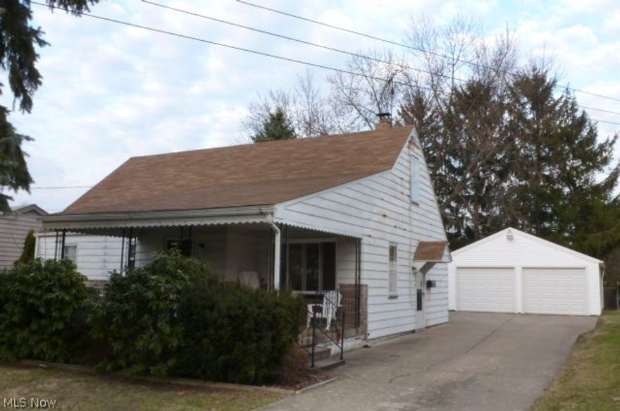 Spacious four bedroom Cape Cod home. Interior includes a kitchen/dinette, large living room, hardwood floors, and full basement. Exterior has a front porch and double detached garage.