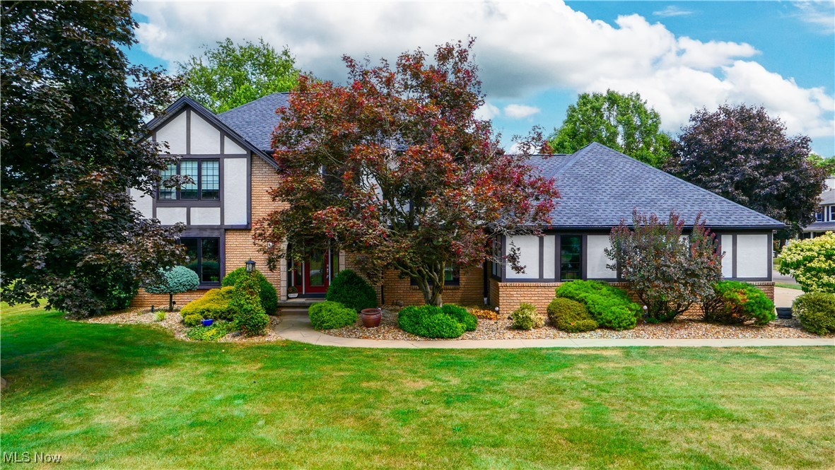 Welcome to this stunning Tudor-style home in Ellet, full of character and modern updates! The amazing curb appeal is enhanced by beautifully maintained flower beds—complete with electric—adding charm and functionality. Step inside to a grand staircase leading to the upper level featuring three spacious bedrooms, a full bath, and a luxurious master suite. The master includes a sliding barn door, rain head shower, soaking tub, walk-in closet, and a double vanity with a marble top. Off the main entry is a spacious office with a brick accent wall and large window, perfect for working from home. The formal dining room offers built-in shelving and flows into the beautiful kitchen, complete with granite countertops, a large island, KraftMaid soft-close cabinets, and a dedicated coffee bar. First-floor laundry and a half bath add convenience. The cozy living room features a gas fireplace, whitewashed accent wall, and French doors that open to a stunning outdoor living space. Enjoy the composite deck, hot tub under a pergola, stamped concrete patio, fire pit area, and expansive backyard with a shed for storage. The large, partially finished basement offers even more living space, an additional half bath, and plenty of room for storage. This one-of-a-kind home blends timeless charm with modern comfort—don't miss your chance to make it yours!