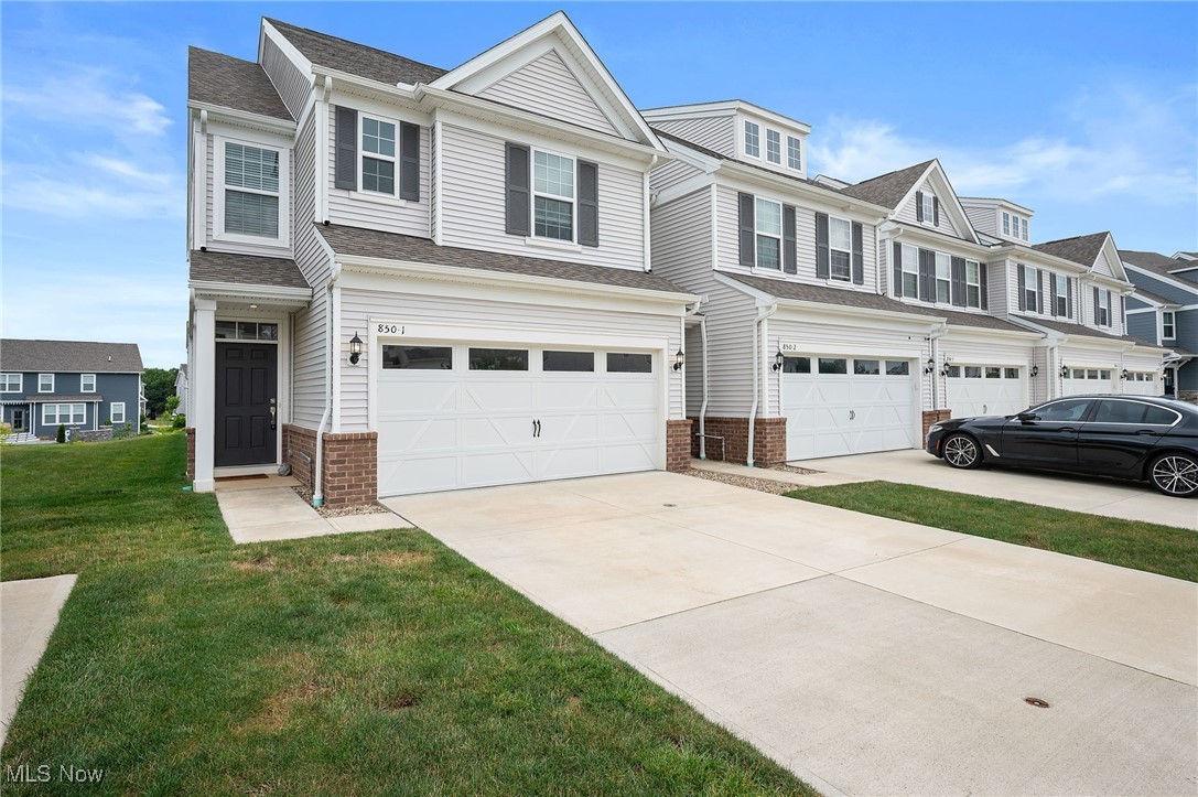 Modern design, low-maintenance living, and a rare end-unit location - welcome to 850-1 Dipper Lane in the desirable Renaissance Park at Geauga Lake, located just steps from the future Geauga Lake Beachfront Park and walking trails. Built in 2022, this 3-bedroom, 2.5-bath townhome offers over 2,000 square feet of stylish, flexible living space - including a bright first-floor garden room that easily doubles as a home office, and a private patio backing to peaceful open green space. Inside, the open-concept layout is ideal for everyday living and entertaining alike. The spacious kitchen features granite countertops, soft-close cabinetry with pullout shelves, a gas cooktop, stainless steel appliances, and an oversized island. The adjacent living area centers around a sleek black electric fireplace and flows naturally into the sun-filled garden room—perfect as a quiet office, reading nook, or bonus sitting area—with direct access to your private outdoor patio. A mudroom with boot bench, cubbies, and coat hooks connects to the attached two-car garage, and a powder room with pedestal sink rounds out the main level. Upstairs, retreat to a generously sized primary suite with its own sitting area, walk-in closet, and en-suite bath featuring a double vanity, walk-in shower, and private water closet. Two additional bedrooms, both with large closets, share a full bath with double sinks and a tub/shower combo. Laundry is conveniently located on the second floor with an oversized washer and dryer. Enjoy a lock-and-leave lifestyle with landscaping, exterior maintenance, and snow removal included. Close to shopping, dining, and recreation, this home combines modern comfort with everyday convenience. Don’t wait for new construction—move right into this like-new, energy-efficient home in one of Aurora’s most exciting communities.
