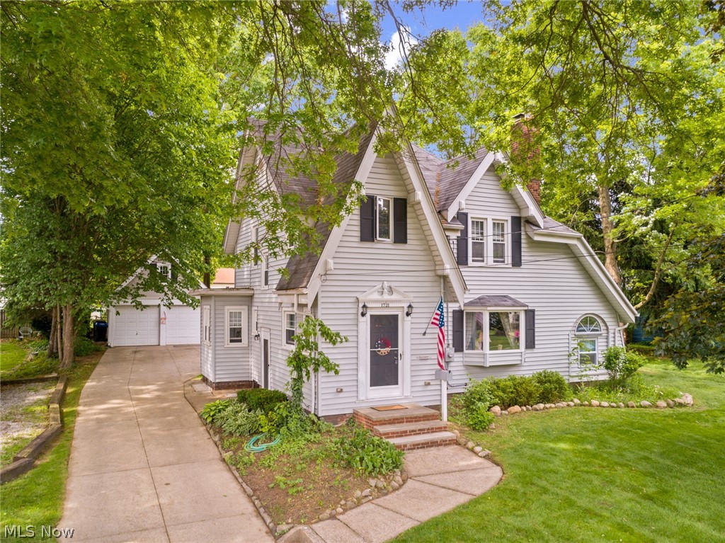 This striking Tudor-style colonial stuns with its curb appeal and beautiful interior. Lovingly maintained, the home boasts the charm of yesteryear with a spacious living room with stone front fireplace, large bay window and a formal dining room – each with original wood floors, crown molding, carved ceiling medallions and some original lighting. The remodeled large kitchen with breakfast nook has newer cabinets, counters, appliances, and the adjoining half bath has also been updated. The newly enclosed portico provides a cozy spot to relax and adds 284 sq. feet of living space to the main area. Upstairs are 3 spacious bedrooms all with hard wood floors. Get lost in the HUGE full bath with original tiling, dressing area, and plentiful storage. The partially finished basement provides additional living area, a second full bathroom, light and clean laundry area, and loads of clever storage. Enjoy the flat and private backyard on the stone patio or convert the space above the 2-car garage