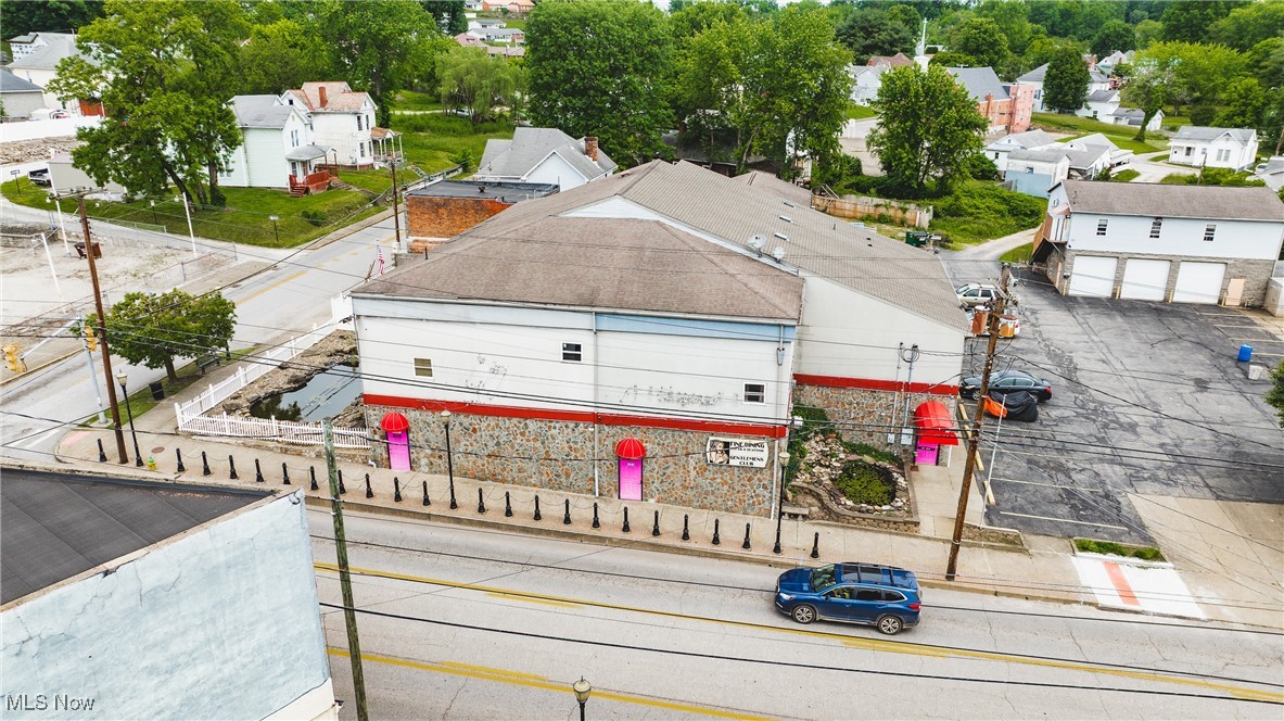 High-Traffic Investment Opportunity in Parkersburg, WV – Six (6) Parcels
Located on high-visibility Seventh Street in Parkersburg, West Virginia, this rare commercial property spans seven parcels in one of the city’s most trafficked areas. Formerly operating as a nightclub, the main structure includes a commercial kitchen, two full bars, public restrooms, and a dressing area—ideal for continued entertainment use or future redevelopment.
The property also includes a variety of income-generating residential units, all with owner-paid utilities, as well as ample parking and an oversized three-car garage with garage apartments. Residential breakdown includes:
Attached Owners Apartment: Elevator access, two bedrooms, one full bath, open-concept kitchen/living area, plus two sleeping
rooms with a shared bathroom (each sleeping room rents for $500/month). Two Garage Apartments (above oversized 3-car garage): One 2-bedroom and one 1-bedroom unit, each renting for $600/month. Two Additional Units: Located near the private courtyard, renting for $700/month and $600/month respectively. Estimated Gross Monthly Rental Income: $4,500 (Based on full occupancy and current rental rates) With multiple income streams, strong commercial potential, and a prime location, this versatile property is an outstanding investment opportunity in the heart of Parkersburg.