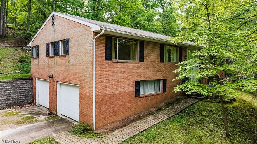 This inviting home is situated in the established Woodland Park subdivision of North Parkersburg. Nestled on a serene, wooded lot elevated above the street, it offers both privacy and a peaceful setting. Inside, you'll find beautiful hardwood floors and spacious living areas, including a generous living room and a downstairs rec room or family room. The property features a master bedroom complete with a master bath, a versatile unfinished utility room, and a convenient two-car garage.  The home is being sold "as is".  The seller will make no repairs.