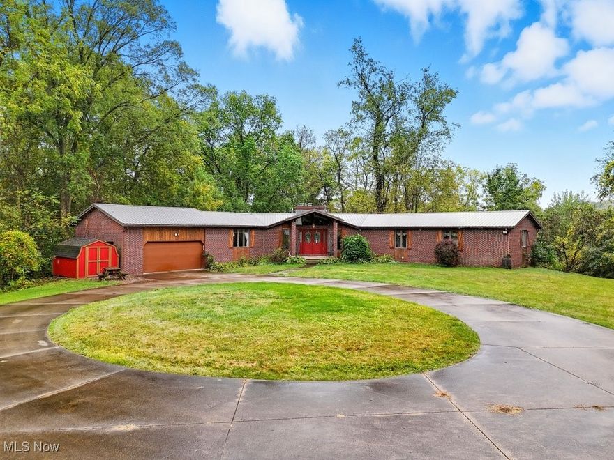 This sprawling, open-concept ranch offers the perfect blend of privacy, comfort, and versatility. Nestled among mature trees on over 2 acres, this beautifully maintained home is a rare find for those who crave space—both inside and out. Step inside to a seamless open floor plan filled with natural light, ideal for both entertaining and everyday living. The heart of the home features a spacious kitchen with bar seating, dining, and the living area that flow effortlessly together, creating a warm and inviting atmosphere. The living room offers access to the deck (2023) and a lovely floor-to-ceiling brick fireplace. Off of the kitchen is a second powder room and garage access. The main level is completed by a spacious Primary Suite with ensuite powder room, WIC and private access to the deck, a full bath with a dressing table, two more generously-sized bedrooms, a laundry closet in the main hall, and an open foyer with stairs to the lower level. Downstairs, the fully finished walkout basement expands your living space with a generous recreation room, a stylish bar area, a second full bath, a storage/utility room, and a bonus room perfect for a home gym, office, or guest suite. An additional room in the basement provides space for a workshop and stairs leading to the attached 2-car garage. Outside, enjoy your own private oasis. Relax on the deck, in the hot tub, or around the cozy fire pit—inviting you to unwind under the stars. A massive new outbuilding/RV/boat garage (2024) provides endless possibilities—whether you're a car enthusiast, need extra storage, or want space for your next big project. The large circular driveway offers convenience and impressive curb appeal. Many recent updates including a brand new metal roof (2025), new AC (2024), a new well pump (2025), and more! This property truly has it all: space, functionality, and the peace of a wooded, country setting—yet still just a short drive to all the essentials, including downtown Wooster.