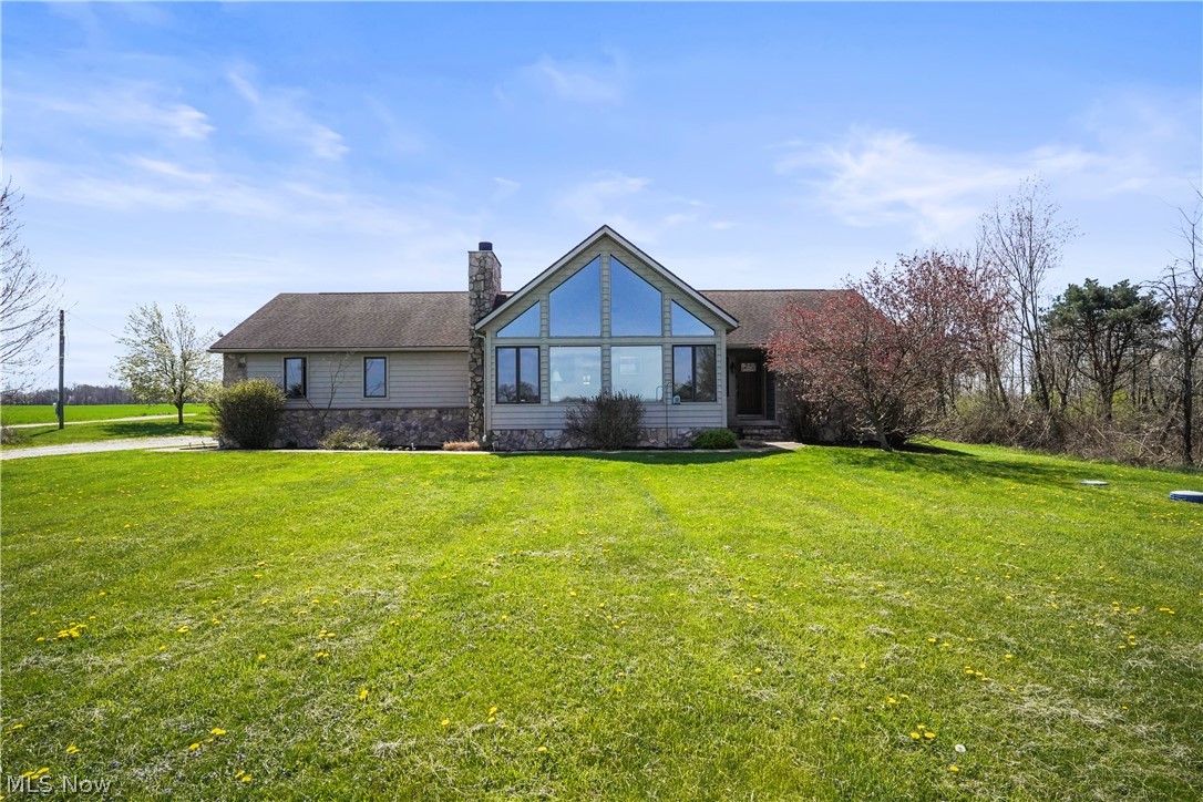 Here you will discover a masterpiece of craftsmanship coupled with serene country living in this custom built ranch set on a picturesque 5 acre estate. This property is a haven for those who appreciate the artistry of woodwork and the tranquility of rural landscapes. Stepping through the spacious foyer you'll find a 22 x 17 Great Room with exposed beams, a vaulted ceiling, a hand built stone wood-burning fireplace plus floor to ceiling A-Frame windows exposing the expansive and wide open view of the front lawn along with a tranquil panorama of the outdoors. The artisan crafted woodwork includes 3 quarter inch hand scraped wood floors in the main living areas plus custom trim and baseboards throughout. The attractive kitchen has beautiful custom built hickory cabinets offering a layout that any chef would treasure. In this open and airy living space there is also a breakfast nook and a separate spacious dining area. The master suite with private bath includes a separate vanity area, generous sized walk in closet and an inviting walk out deck with unobstructed views that stretch to the horizon with no other homes to mar the pristine landscape. Two additional guest bedrooms, a full bath and a great laundry room complete the first floor. You'll also appreciate the 3 car garage and expansive open basement. Stepping outside there is a beautifully designed flagstone patio shaded by a new cedar pergola. Recent updates include: new water heater, dishwasher, microwave and water softner repaired.. This home is nestled away from the hustle and bustle yet centrally located between downtown Louisville, Hartville and Alliance . Don't delay to schedule your private viewing today.