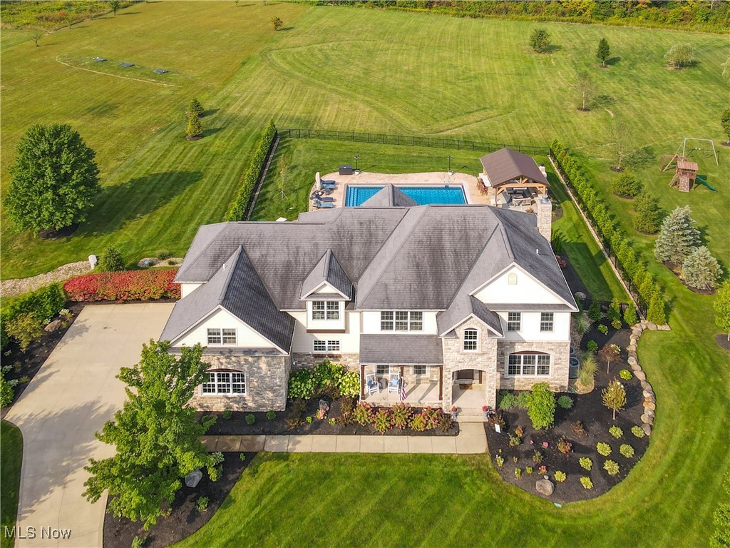Welcome to this beautifully updated and meticulously maintained home in the highly desirable Amber Trails development.Situated on 2.5 acres in Bainbridge,this home showcases true pride of ownership.Step into the spacious foyer featuring wide-planked hard-wood floors and classic wainscoting.Just off the foyer,you'll find a formal dining room with tray ceiling,a private office, and an updated powder room.The two-story great room is ideal for entertaining,with a dramatic wall of windows,stone-front gas fireplace, custom built-ins,and a bar with wine refrigerator.The remodeled gourmet kitchen is sure to impress any chef,featuring a Wolf oven,steam oven and gas cooktop as well as a Sub-Zero refrigerator.A center island,Calcutta quartz countertops, and custom tile back-splash provide both elegance and efficiency.The cozy breakfast nook offers an unparalleled view of the beautiful back yard and pool area.A conveniently located service area includes a walk-in pantry,laundry room,2nd updated guest bath and a mudroom with cubbies and convenient access to the patio and pool areas as well as the 3 car garage. Upstairs you'll find 4 large bedrooms, each with bath access.The luxurious primary suite features a large sitting room,dual walk-in closets,a well appointed ensuite bath and a private screened in porch.Head down to the finished lower level where you'll find a recreation room,media area,full bath,bar and 500 bottle wine cellar.The true showstopper is the entertainment-ready outdoor space featuring an expansive stone patio,20x40 heated pool,gas firepit,and hot tub.The custom built pool pavilion is fully equipped with a granite topped bar, outdoor refrigerator, outdoor tv, gas grill, and a gas fireplace and heater-perfect for hosting all season long.This luxurious home blends timeless charm with state-of-the-art upgrades.With over $300k in renovations since 2022 it is not to be missed!Kenston Schools,Geauga taxes and no RITA.See supplements for full list of upgrades.