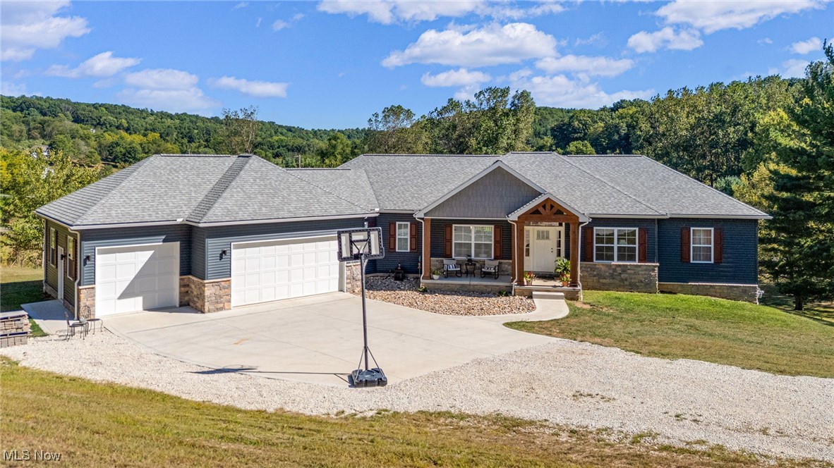 Stunning newer-built (2023) Schumaker home at Lake Mohawk on two lots with year-round lake views! The open floor plan is filled with natural light, soaring cathedral ceilings, and features a large quartz kitchen island, gas stove, and cozy gas fireplace. The private main ensuite is tucked away in its own wing with two walk-in closets, double quartz vanities plus makeup counter, linen closet, and a spacious walk-in shower. Two additional bedrooms and full bath are located in the opposite wing. Main level also includes a laundry room and half bath. The walk-out lower level is partially finished and offers endless possibilities, plumbed for a full bath. Oversized 3-car garage plumbed for gas heat. Easy access to the lake's back gate, allows for a quick commute to Carrollton or Canton. Enjoy all the amenities of Lake Mohawk—unlimited horsepower boating, swimming, 3 beaches, fishing, tennis, pickleball, clubhouse, and 24/7 gated security.