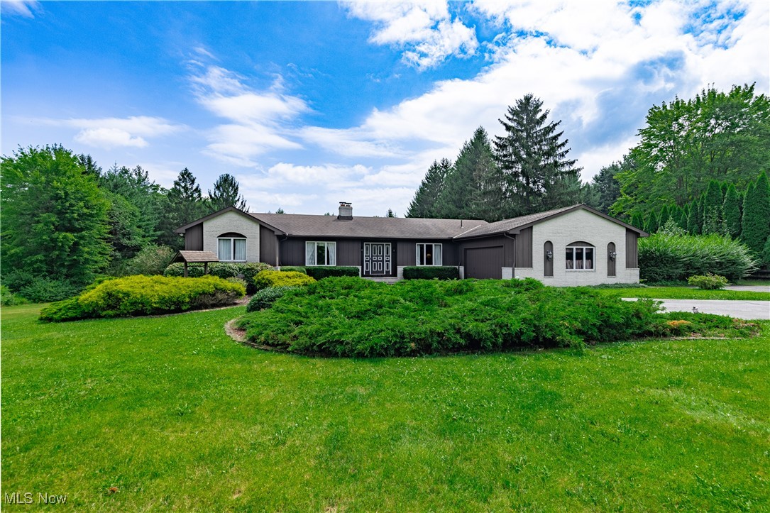 Welcome to this spacious and well-maintained one owner ranch, located on a picturesque 4.57 acres in the Kenston Local School District. This lovely 4 bedroom, 3 full bath home is filled with character and space for comfortable living. Step through the front door to a large functional foyer. To the left is a living room with a corner wood-burning fireplace and lots of natural light. Off to the right is a versatile den or office with the potential for a fifth bedroom ideal for guests or your needs. A few steps away, the home opens into the roomy eat-in kitchen which features countertop seating, ample cabinet space, and a dining area. The convenient first-floor laundry room and extra bonus room off the kitchen have plenty of room for extra storage and counter space. The sunken family room, which has easy access to the backyard, boasts wood ceiling beams, a brick fireplace for cozy evenings, and multi-functional seating and built-in storage that add warmth to the home. Downstairs, the partially finished basement offers a recreation room and flexible bonus space perfect for an office, gym, craft room, or anything you can imagine. On the main floor, the primary bedroom provides a separate seating space with a vanity, walk in closet, and attached primary bathroom. Double doors lead to the large, newly painted deck that looks out into the gorgeously landscaped private backyard, giving the home a natural, retreat-like setting. The backyard features an in-ground pool (new pool filter and pump installed in 2022), gazebo, pond, and two barns with electricity and water. The attached two-car garage has a side door that opens to the backyard patio, creating another place for outdoor entertainment. Don't miss your chance to own this gem -- schedule a showing today.