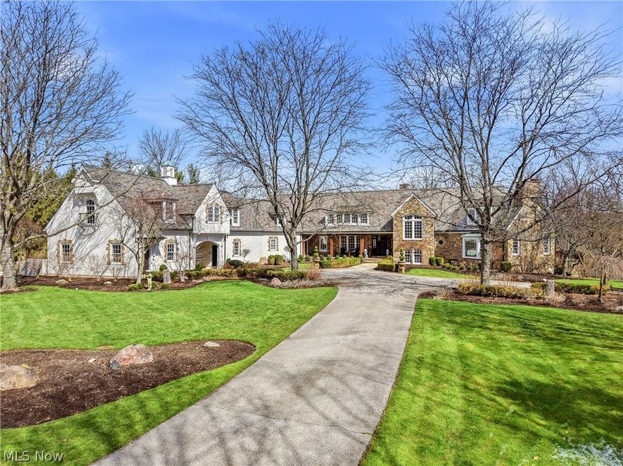 Tucked at the end of a quiet cul-de-sac and backing to the protected beauty of the Metroparks, this extraordinary Paskevich-designed estate is a rare offering—where timeless architecture, thoughtful craftsmanship, and modern livability converge in a setting of complete privacy. A long approach reveals a striking exterior of stone, stucco, and slate, complemented by copper detailing & artfully designed landscaping that unfolds across the property. Inside, the home opens w warmth & intention. Rich hardwood floors, extensive millwork, and hand-hewn beams set the tone. The main kitchen serves as the heart of the home—beautifully reimagined w custom cabinetry details, handcrafted millwork + a full suite of professional-grade appliances. It flows effortlessly into the hearth room and provides a sense of gathering & ease. The first-floor owner’s suite is a private sanctuary, complete w serene views, wood paneled office and large en-suite marble bath. Upstairs, 4 bedrooms offer comfort & individuality—each with custom built-ins—while a thoughtfully designed bonus space adapts beautifully for what you need  as additional flex space. The attached guest residence/in law suite is a home of its own, with a private entrance, full kitchen, living + dining spaces & laundry. The lower level is expansive & designed for both entertaining and retreat, featuring a full kitchen, recreation & billiards areas, a home theater, a wine cellar, fitness space, and sauna. Walk-out access connects directly to the outdoor living areas & pool. Outdoors, every element has been considered—from the redesigned landscape & irrigation system to the custom playground, garden beds & inviting gathering spaces. The setting is both grand & intimate, designed for quiet mornings, lively gatherings & everything in between. This is a home that lives beautifully—where architectural integrity meets modern refinement, and where every detail has been carefully considered to create an exceptional everyday experience.