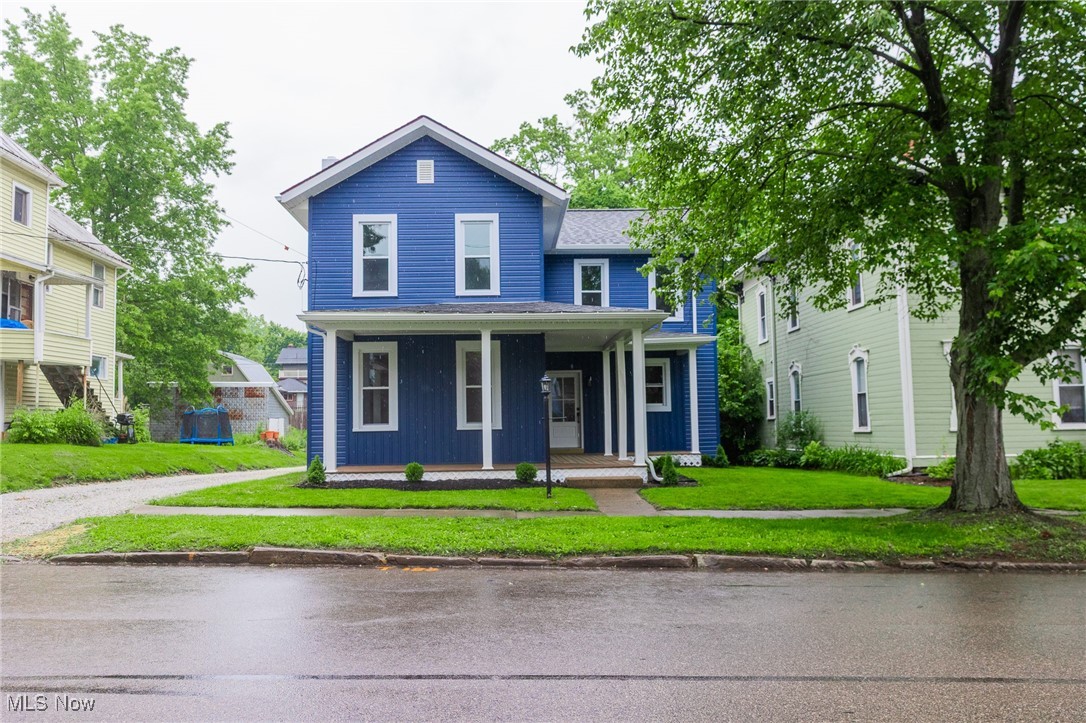 This fully remodeled 4-bedroom, 2-bath home in Wooster offers modern living with a fresh exterior featuring vinyl board and batten siding, new doors, windows, electrical, and plumbing. Enjoy the charm of a wraparound front porch and the privacy of a fenced backyard. Inside, the home boasts a stylish kitchen with new appliances, a tile backsplash, and an island, all opening to a spacious dining and living area. The open staircase leads to a roomy upstairs with a full tub-shower bath, while the main-level master suite includes a walk-in tile shower. Convenient main-floor laundry, abundant natural light, and a cozy atmosphere enhance the appeal. A detached two-story garage and gravel parking area complete this like-new home in a desirable neighborhood.