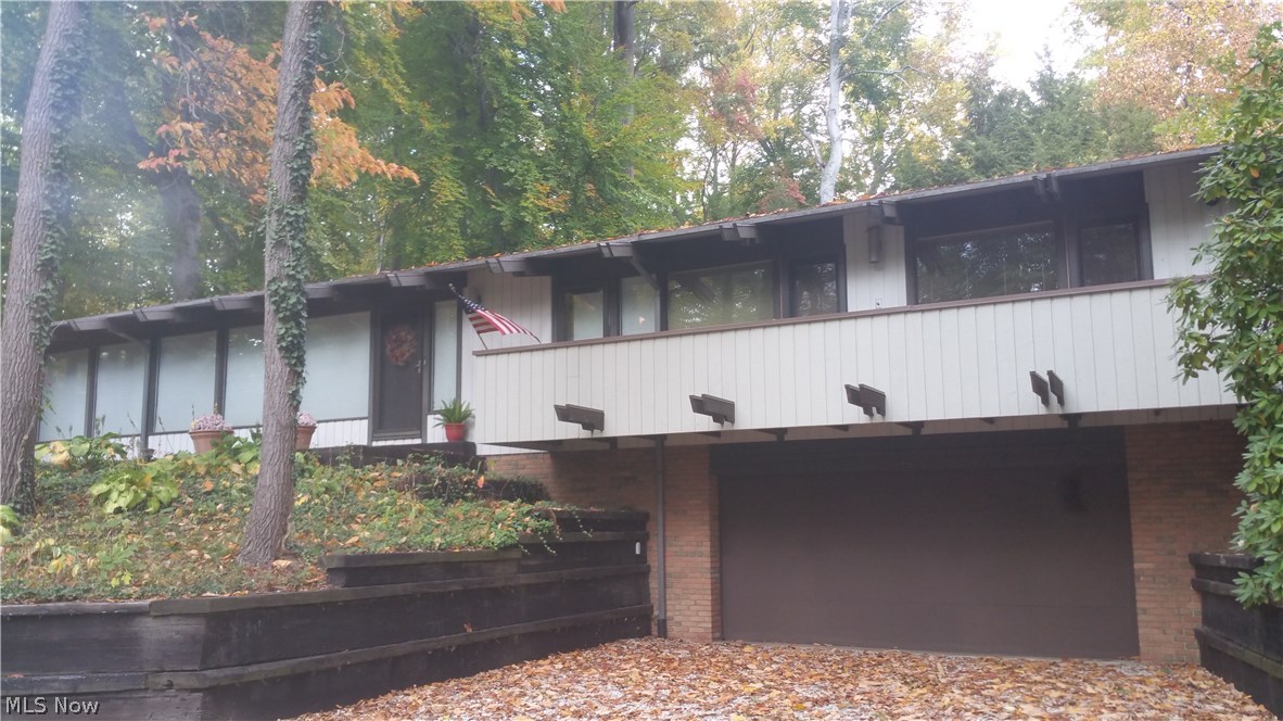 If you love nature’s beauty, and are tired of looking at cookie cutter homes, you’ll love this architecturally-designed, 3-bedroom contemporary raised-ranch retreat, in Munroe Falls. It’s hard to find one like this; with tongue-in-groove white fir ceilings, skylights, a living room with walls of windows, from which you’ll see all kinds of wildlife and can grow plants all year ‘round, a galley kitchen with loads of custom made birch cabinets and lots of counter space for preparing food, or putting food out for guests! All of the bedrooms feature open ceilings, and from all three you can walk out to a pretty, wrap-around deck! There’s a sprawling lower-level family room with a built-in desk area, a large built-in storage cabinet and a walk-out to the 2+ car garage. Been looking for storage space? The house is brimming with storage closets and cubbies! The mechanicals have been serviced regularly, and if you like to tinker on projects at home, the utility area has a fantastic workbench a