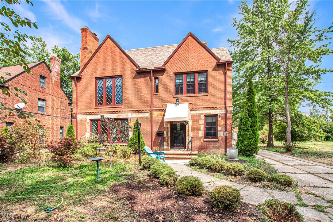 Quality-built and beautifully updated home in the historic Ludlow neighborhood! This 1940s brick home perfectly blends original character with modern updates, just one block from the newly built Ludlow School and walkable to parks, Shaker Square, library, grocery, shopping, and rapid transit. The sun-filled main floor features a formal living room with a cozy gas fireplace and replacement architectural casement windows that retain the classic Tudor harlequin mullion design. The dining room opens to a covered patio and backyard, ideal for entertaining. The updated eat-in kitchen showcases designer-selected cabinets, stainless steel appliances, quartz countertops, and new flooring, while the den/office provides a private work-from-home space. A convenient half bath completes the main level. Upstairs, two bedrooms share a Jack-and-Jill full bath, and a third bedroom includes access to the rear rooftop balcony, with a second full bath off the hall. The finished third floor offers a fourth bedroom and a third full bath, adding over 400 sq. ft. of flexible living space. Home improvements include $15,000–$20,000 in landscaping, with $10,000 invested in the front yard featuring trees, shrubs, birch trees, wildflowers, Japanese maple trees, bird baths, lanterns, and new awnings—making this home a certified wildlife habitat! Additional updates include central air, refinished quarter-sawn oak floors, Anderson replacement windows, updated 200 amp electrical service, replacement gutters, downspouts, and fascia. The fenced yard provides privacy and space for outdoor enjoyment. This Ludlow gem offers the perfect combination of historic charm, modern comfort, and thoughtful upgrades—ready for you to move in and enjoy!