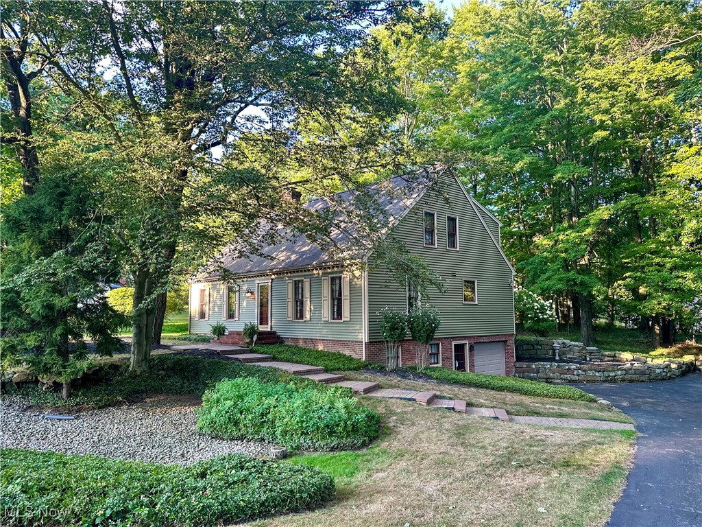 Nestled on a shaded half-acre lot on a quiet street, this charming Cape Cod blends classic appeal with modern comfort amidst a serene, impeccably kept neighborhood. Boasting nearly 2,500 square feet of inviting living space, the home greets you with brick walkways, stone walls, and lush landscaping that create standout curb appeal. Inside, a welcoming foyer leads to a formal living room with a gas fireplace and a generous dining room, both bathed in natural light from large windows. The cozy, wood-paneled family room offers built-in bookshelves and a second fireplace for chilly evenings, while the eat-in kitchen provides ample space for meal preparation and casual dining. A convenient laundry closet sits in the kitchen, with basement hookups if you’d prefer to use the closet as a large pantry. A handy half-bath completes the main level. Upstairs, the spacious primary suite features a walk-in closet and an attached bath, delivering a relaxing retreat after a long day. Two nice-sized bedrooms and another full bath provide plenty of space for loved ones and guests. Other notable highlights include a full walk-out basement with rec room, a beautiful stone patio for al fresco dinners, an attached garage, and an oversized driveway for extra parking. All of this is set in a peaceful neighborhood just moments from Youngstown Country Club, recreation, schools, and dining options. This home offers a delightful blend of classic charm and practical comfort in a prime location.