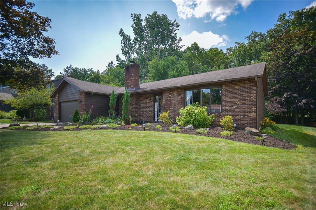Looks Can Be Deceiving—This 3-bedroom, 3-full-bath ranch with attached 2-car heated garage just keeps going! From the moment you step inside the formal foyer, this home surprises at every turn. To the right, the sunlit living room features a large picture window and flows seamlessly into the dining room. The kitchen is open to the dining area, boasting stainless steel appliances, granite tile countertops, white cabinetry, and a breakfast bar overlooking the private, tree-lined backyard. A spacious family room with a wood-burning fireplace and whitewashed brick is the perfect gathering spot, with a sliding glass door leading to the deck, paver patio with a firepit, and built-in outdoor kitchen with a JennAir grill and granite counters. The bedroom wing includes a primary suite with two closets and a private bath, two additional bedrooms, a full guest bath, and a beautifully updated laundry room with built-in cabinetry. The lower level is truly spectacular—featuring a home office area, optional 4th bedroom, workout room, full bath, and a massive rec room with a bar and built-in aquarium, plus plenty of storage. Recent updates include a hot water tank installed in 2024 and the furnace and central air conditioning system replaced in 2022. All ceiling fans have been replaced, and the sump pump has been upgraded with GFCI and a PitBoss system. The HOA amenities include a pool, basketball, volleyball, and tennis courts, a stocked catch-and-release lake, two pavilions, and scenic common areas. Located close to highways, Metroparks Mill Stream Run, this home offers a private creek in the backyard for the ultimate serene setting.