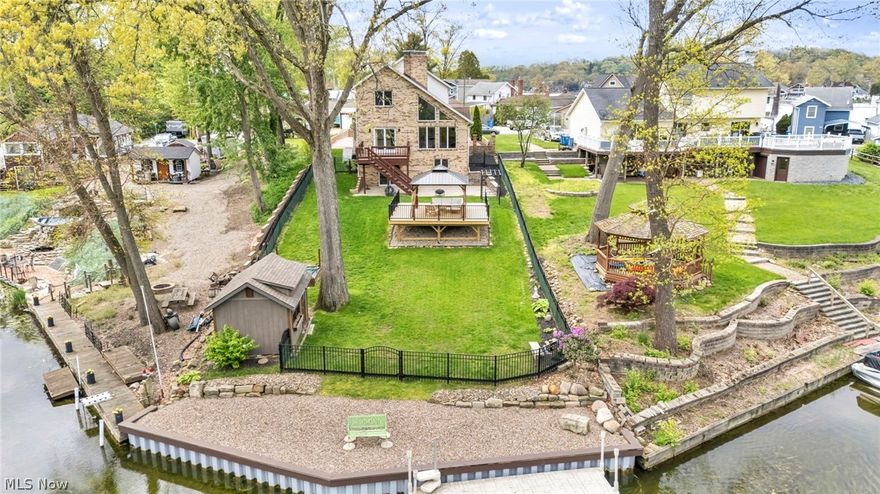 Here's your chance to own a rare brick beauty on the main chain of Portage Lakes -- Meticulously cared for by the same owner for 27 years, pride of ownership shows. Situated on a quiet & private quiet end of East Reservoir, yet still connected to the main chain and all the action!  This unique contemporary style home features 4 beds & 3.5 baths w/ big ticket updates throughout. Enter first floor living room with beautiful two story brick fireplace with stunning views of the lake. Living area connects to dining room, kitchen, family room, and half bath. Upper level has 3 bedrooms; including giant master suite with updated master bath, walk-in closet, a guest bath, 2nd floor laundry, and two bedrooms. Lower level walkout rec room with fireplace and built-ins, additional full bath, and 4th bedroom. Brand new carpet on top level, beautifully refinished hardwood floors, and freshly painted throughout. Seller has made numerous updates including: Reno to Master bath, guest bath, half bath, and kitchen. Dock, seawall, concrete patio and wall, fence, and lower level deck with gazebo were all updated within the last few years! Seller has also replaced HVAC, hot water tank, water softener system, roof, washer/dryer, and dishwasher. The yard is perfect for relaxing and entertaining, with two decks, stamped concrete patio, and plenty of green space. Extra large brick driveway has plenty of parking for all your guests you'll have over this summer! Don't miss your opportunity to own this beautiful move-in ready lakefront home!