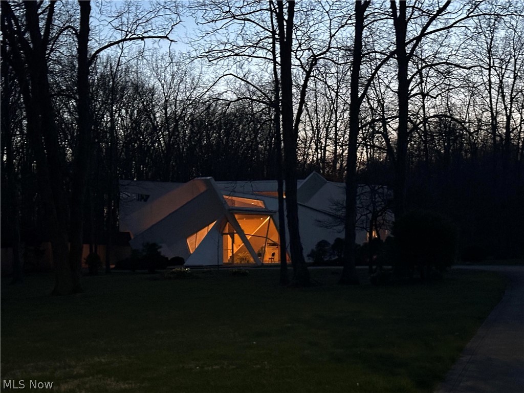 Move to one of the most contemporary homes in the area, tucked amidst native woods, yet near to local neighborhoods and communities. Nearby bike path extends to regional towns, and sidewalks extend to local downtown and college campus; a nearby trailhead leads to an abutting nature preserve with one of the most scenic reservoirs and migratory birdwatching areas. Join the adjacent golf club and invite friends to play! A winding drive leads to the front patio and a welcoming atrium bathed in light throughout the year: a great place for your displays and happy plants. Double doors open to a grand room with beautiful acoustics and views to the rear woods. A private first-floor guest suite and the nearby kitchenette is perfect for in-laws, caretakers, or extended families. A bonus first-floor studio enables focused creative work but could also be easily converted to a third bedroom. The upstairs is your private retreat with expansive living spaces and treehouse-like views. The sensuous kitchen has cabinets made by Ferrari Co., so it is a true Ferrari yellow! A central “floating” dining room overlooks the interiors below as well as the entry driveway. The main bedroom has long clerestory picture windows and a private balcony. A custom-designed en-suite bath is large enough for a tub and surround, tiled large shower, and spacious dressing areas. Off the upstairs living areas, is a beautiful study/office/library with custom-built quartz counters, also a perfect place for your daybed. Desirable features include accessibility throughout, commercial grade fixtures and finishes, warm bamboo floors, generous hallways designed as display galleries, zoned heating/cooling, heated 3-car garage, and a landscape design featuring small gardens including a Japanese bamboo courtyard. Make this your dream retreat with a front-seat view to the changing seasons at their finest - schedule your tour today!