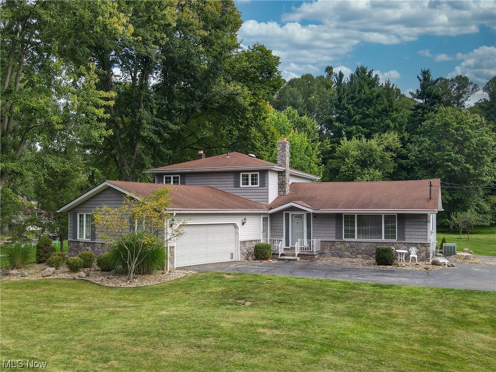 THE HIDDEN GEM WITH ENDLESS POTENTIAL! Tucked away in the Village of Walton Hills, at the end of a very, long driveway, is the opportunity to bring all of your Chip and Joanna Gaines inspiration, as this home has plenty of room for growth and transformation. The sun-filled combination living room/dining room enters the eat-in kitchen (so many cabinets) and a slider door takes you to the deck for sunrise breakfasts. Two steps down to the family room with original, not painted, wall of stone fireplace, also has a slider door to the paver patio for alfresco dinners. Off of the family room is the ??? You guessed it! FIRST floor master bedroom AND bathroom. Ideal for in-laws or guests, private and convenient. The generously sized laundry room provides no more balancing acts with baskets and is the size of a mini kitchen! UP to the second floor another master bedroom with a full bath along with 3 more bedrooms and the main bathroom. But hold your breath, because the crown jewel is yet to be