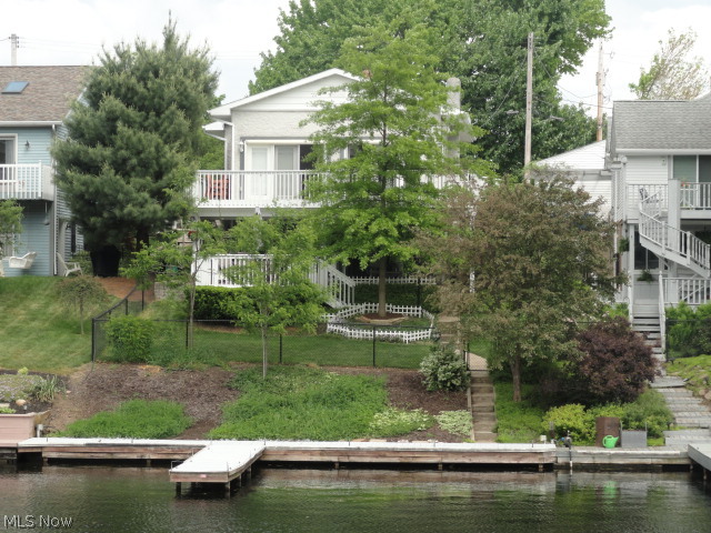 Vacation year round from this lake front home in beautiful Portage Lakes! Both levels of this 2-story home have glass doors across the back that step out to deck porches for you to sit and enjoy the lake view or follow the path to the fenced yard, seawall and private boat dock. Extensive updates include carpet, newer roof, windows, electric, plumbing, septic line, insulation, ceiling fans, water heaters, and more! The remodeled kitchen includes new cabinets, counters, floors, lighting and top grade appliances. Lower level has heated floors for extra comfort if needed and there is two gas fireplaces. Hot tub included. Don't hesitate, call today!