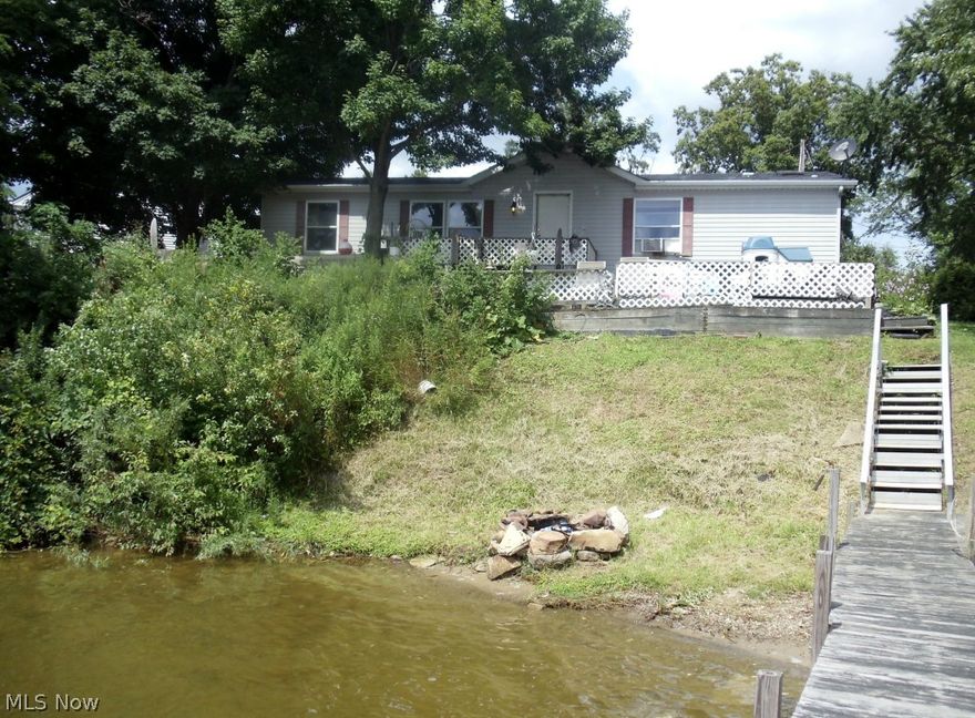 Come enjoy Lake Front Living with easy access to Highways and State Park. This 3 bedroom, 2 bath Manufactured Home  being, with a newer 30 year roof (2007)being sold AS IS.  Boast stunning views from your living room, 2 tiered deck & personal dock providing you with the perfect setting to relax. Gas & water lines have been run to property, yet to be connected. Owner relocating out of state & willing to look at all reasonable offers.