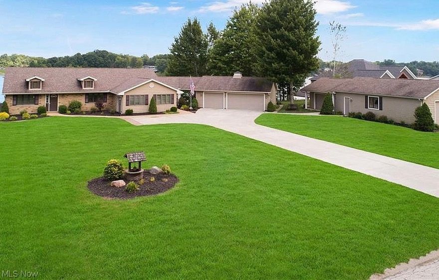 Best home location in Roaming Shores? We believe you'll think so when you see this gem! Meticulously maintained brick ranch on 2 big lake front lots with breezeway, 3 car garage, 24x36 storage building, and an extra wide paved drive leading to all. Not only do you have a great lake location because of access to, and views of the lake, but you're so close to the pool, beach, concession stand, and main clubhouse! Located on one of the widest parts of the lake, this home affords you perfect panoramic lake views including the July 4th fireworks, over 2,300 square feet of stamped, tiered, and textured concrete outdoor deck areas for entertaining, THE BEST decorative waterfall and flowing stream (with 2 bridges!) on the lake , TWO beautiful fire pit and seating areas (one for the beers and one for the S'mores), and even a paved golf cart path to the dock and lake areas! And the dock! Super solid seawall with concrete boardwalk! Simply fantastic! All these fantastic outdoor amenities combine