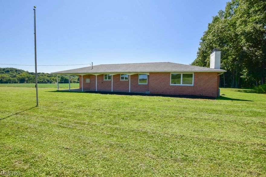 Surrounded by farmland without a neighbor in sight sits this beautifully remodeled all brick ranch featuring 4 bedrooms and 2.5 baths! The covered front porch is the perfect spot to relax and enjoy the country views.  Step inside to the living room with a propane gas fireplace as the focal point. The open concept keeps everyone connected to the eat-in kitchen complete with granite countertops, bright white cabinetry and stainless steel appliances.  In the hall leading to the attached two car garage you'll find a laundry room plus a half bath with a convenient pantry storage closet. The oversized garage includes new door openers, glazed tile walls, and access to the covered patio.  Three bedrooms are on the main level including the primary bedroom with double closets and a private full bath with separate vanities. Secondary bedrooms share the main full bath with a tub/shower with tile surround in the hall.  Even more living space can be found in the lower level adding a spacious rec roo