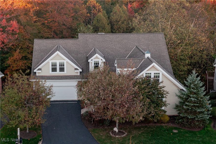 Timeless, elegant, and perfectly maintained—this Canyon Lakes home combines the space of a single-family residence with the ease of condominium living. Perfectly positioned against a tranquil wooded backdrop, this impressive home provides over 6,600 sq. ft. of living space with a first-floor primary suite, a walkout lower level, and a spacious deck ideal for outdoor relaxation and entertaining. A grand two-story foyer welcomes you into the home, opening to a private study through French doors. The formal dining room with crown molding and large windows flows seamlessly into a custom kitchen with granite countertops, stainless steel appliances, abundant cabinetry, and bar seating. The adjoining casual dining area opens to the back deck, creating easy indoor-outdoor living. The inviting family room centers around a wood-burning fireplace with slate surround and expansive windows showcasing picturesque views. A half bath, laundry room, and garage access complete the first floor. The luxurious first-floor primary suite offers high ceilings, deck access, a spa-like bath with dual vanities, soaking tub, and walk-in shower, plus a custom walk-in closet. Upstairs are three spacious bedrooms, two full baths, and a generous landing area. The walkout lower level provides incredible versatility with a large living area, gas fireplace, additional room for a guest suite or office, a half bath, and access to the wooded backyard. Located in the desirable Canyon Lakes community of Chagrin Falls, this home is moments away from area shops, dining, and parks, just minutes to the village.